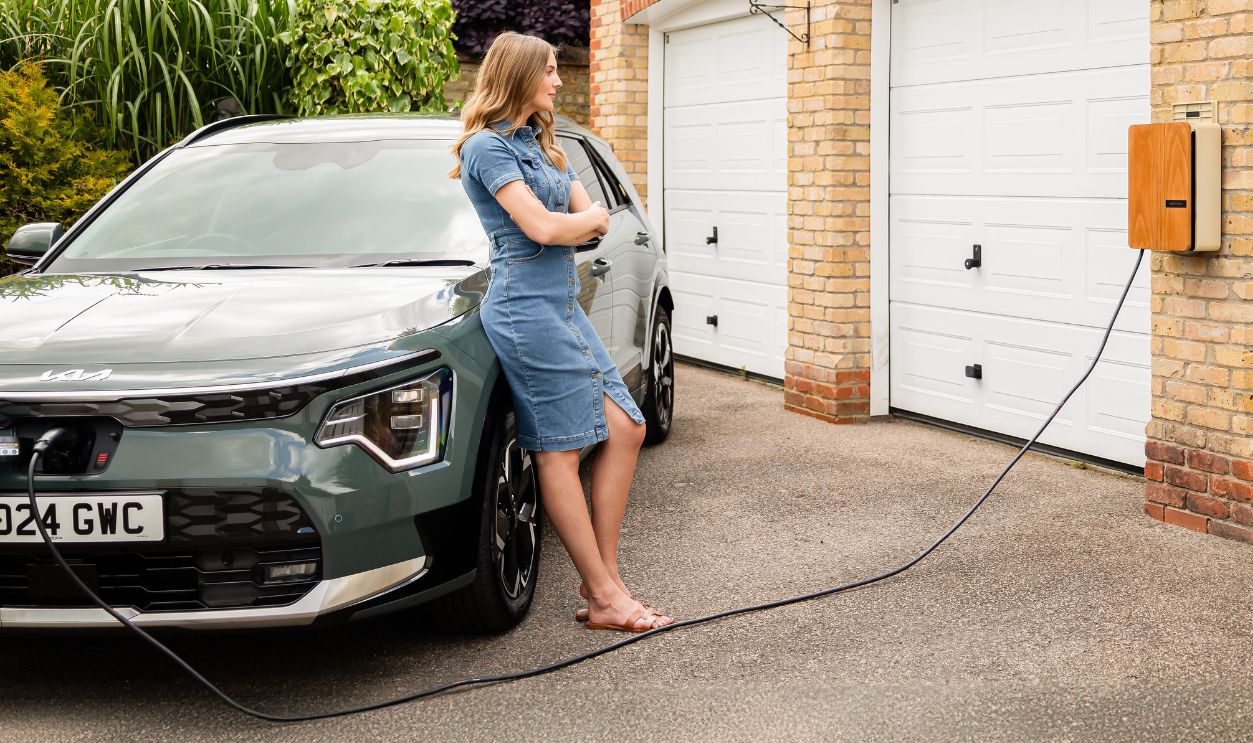 Woman charging electric vehicle at home