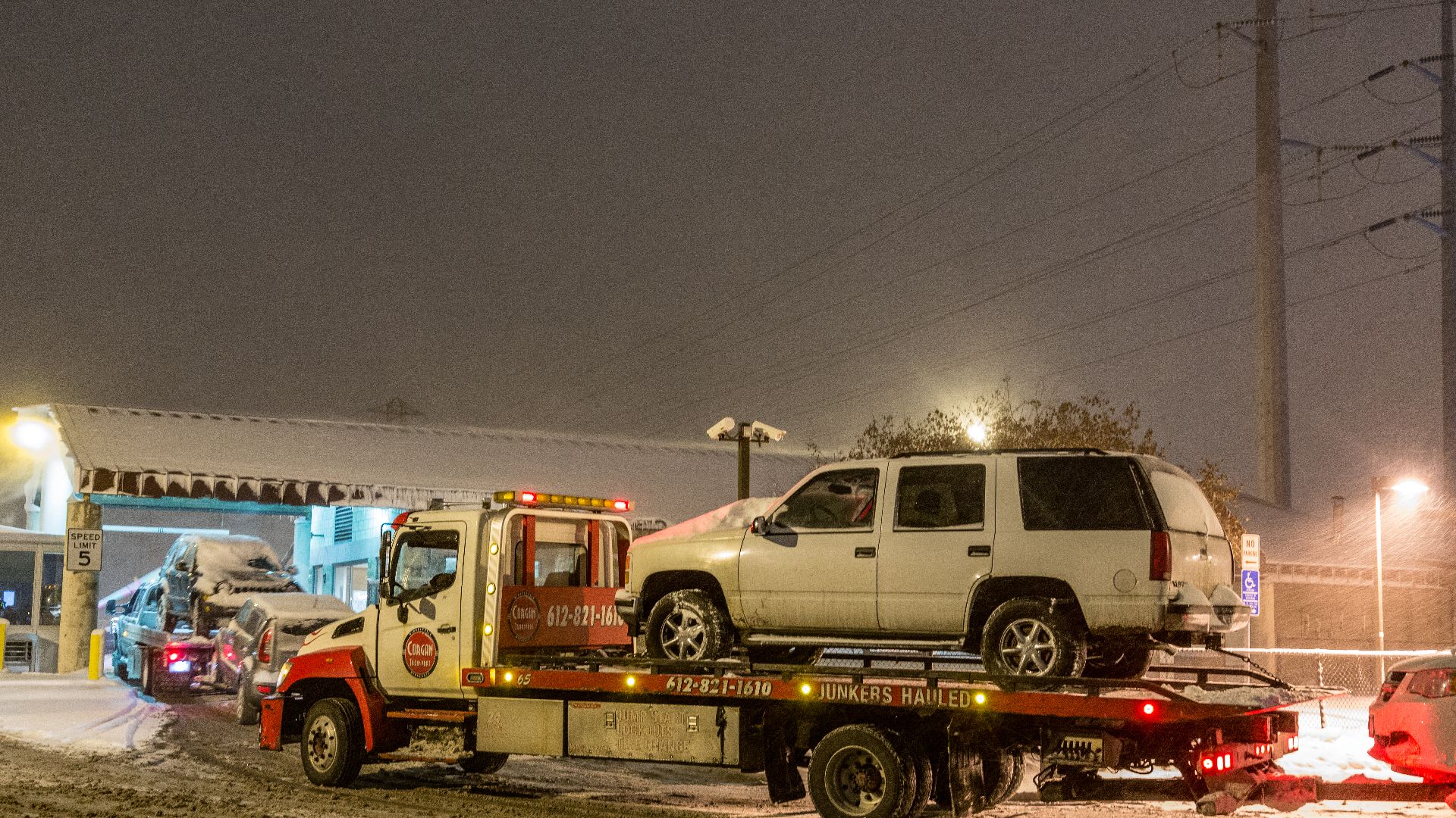 Tow trucks line up to drop towed cars off at the City of Minneapolis Impound Lot located at 51 Colfax Ave N in North Minneapolis, during a winter storm and declared snow emergency.
