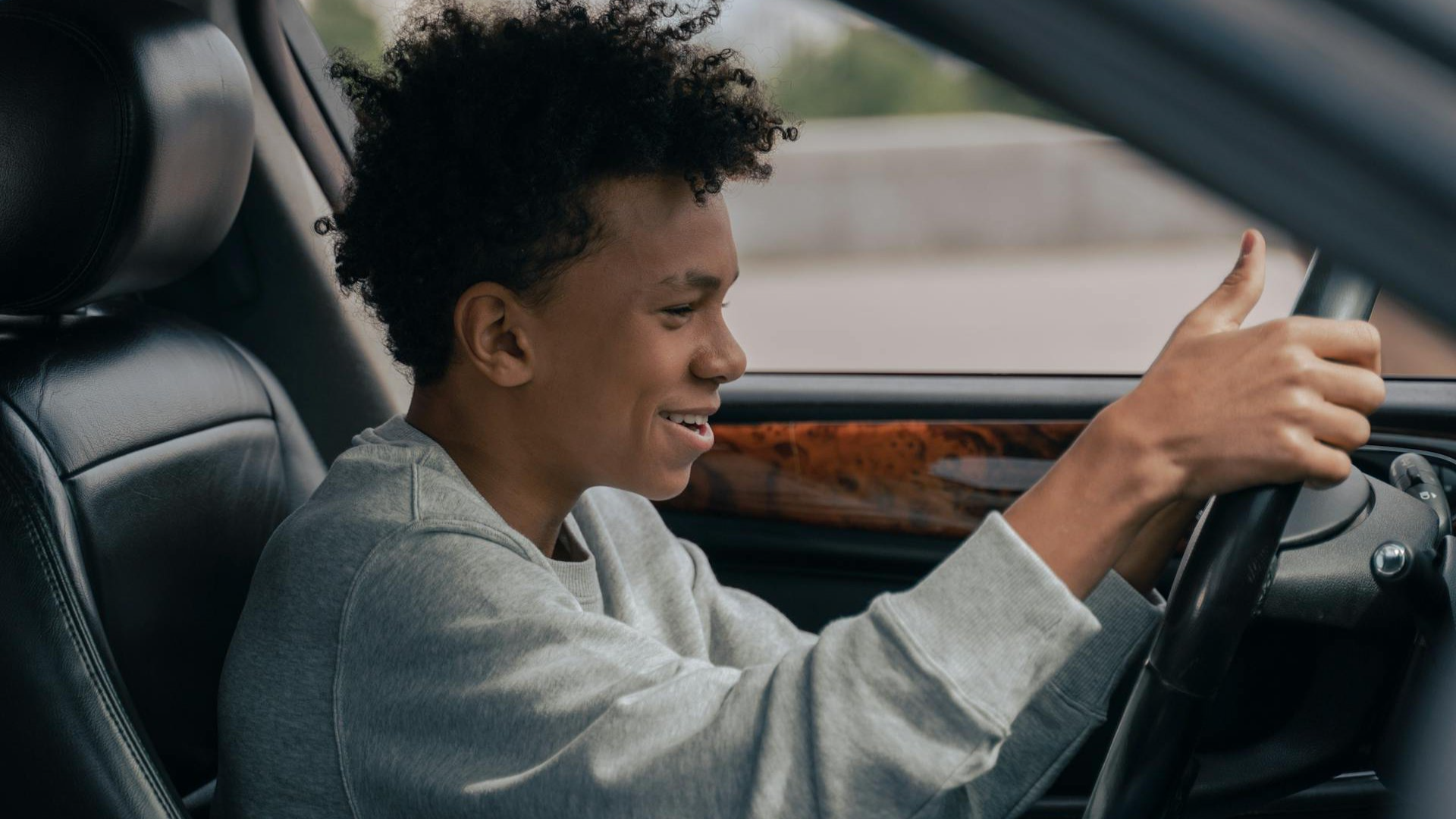 Man in Gray Hoodie Driving Car.