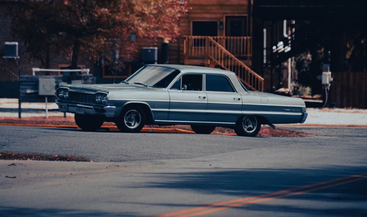 Vintage car parked on a city street against a building backdrop