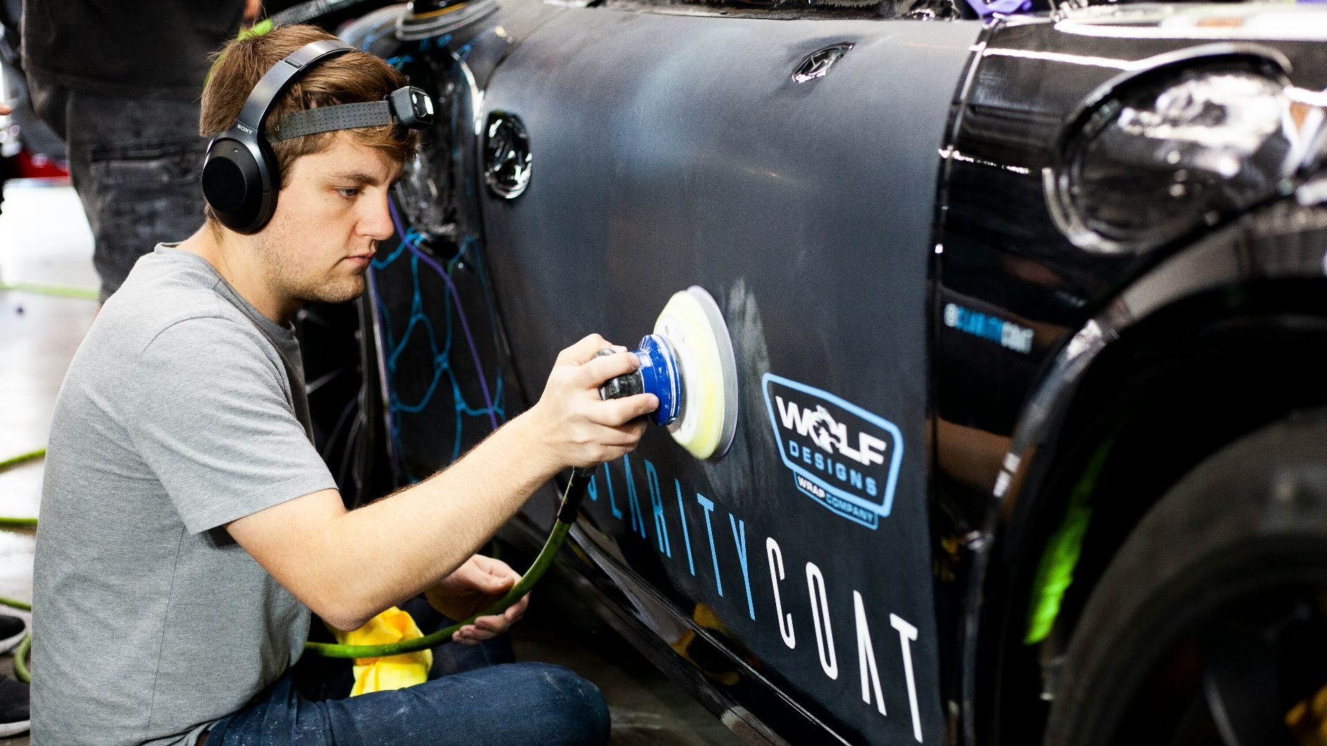 a man is painting a car with a spray gun