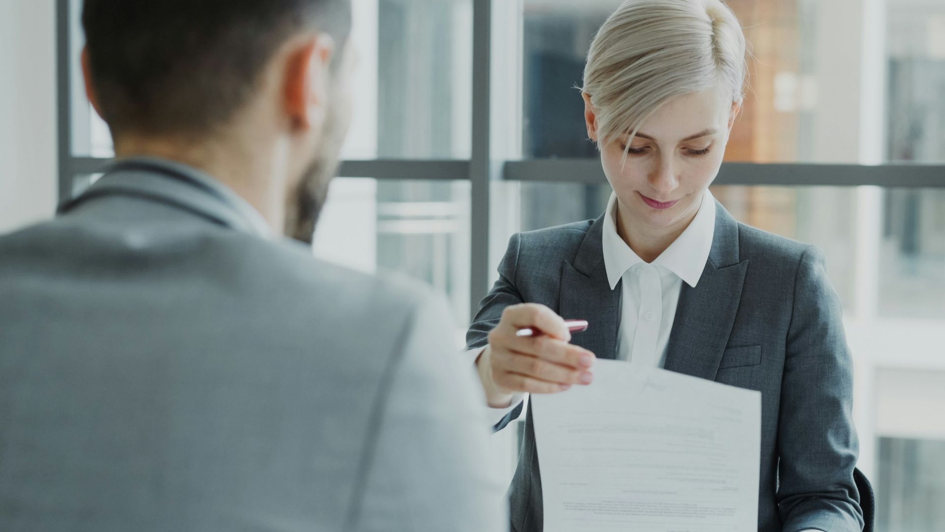 Woman in suit shows document to man