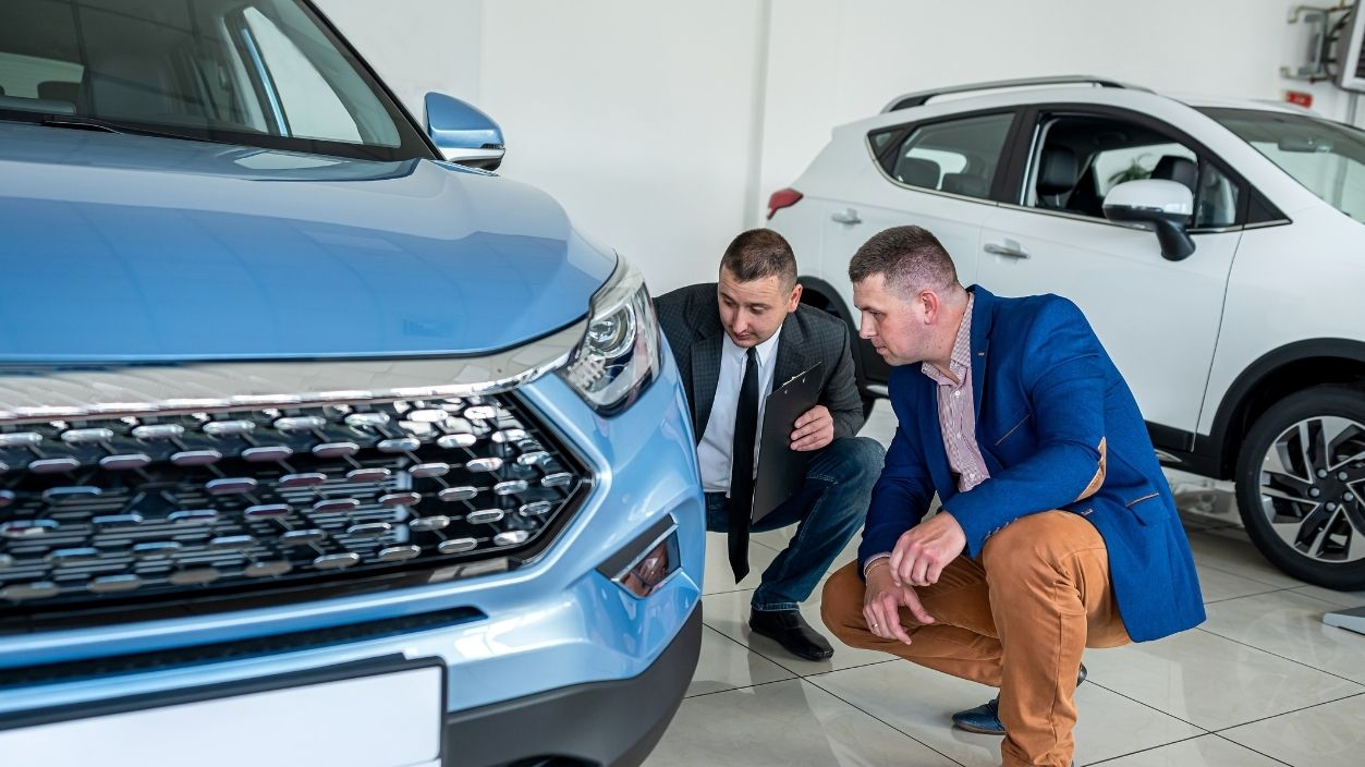 Shutterstock-2319539985, Young professional manager and male client choosing and examining a new auto before purchase in dealership