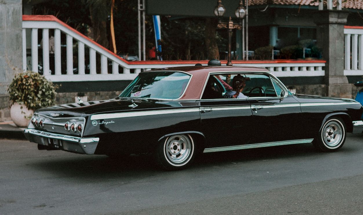 Vintage car participating in a street event in Indonesia, showcasing classic automotive style