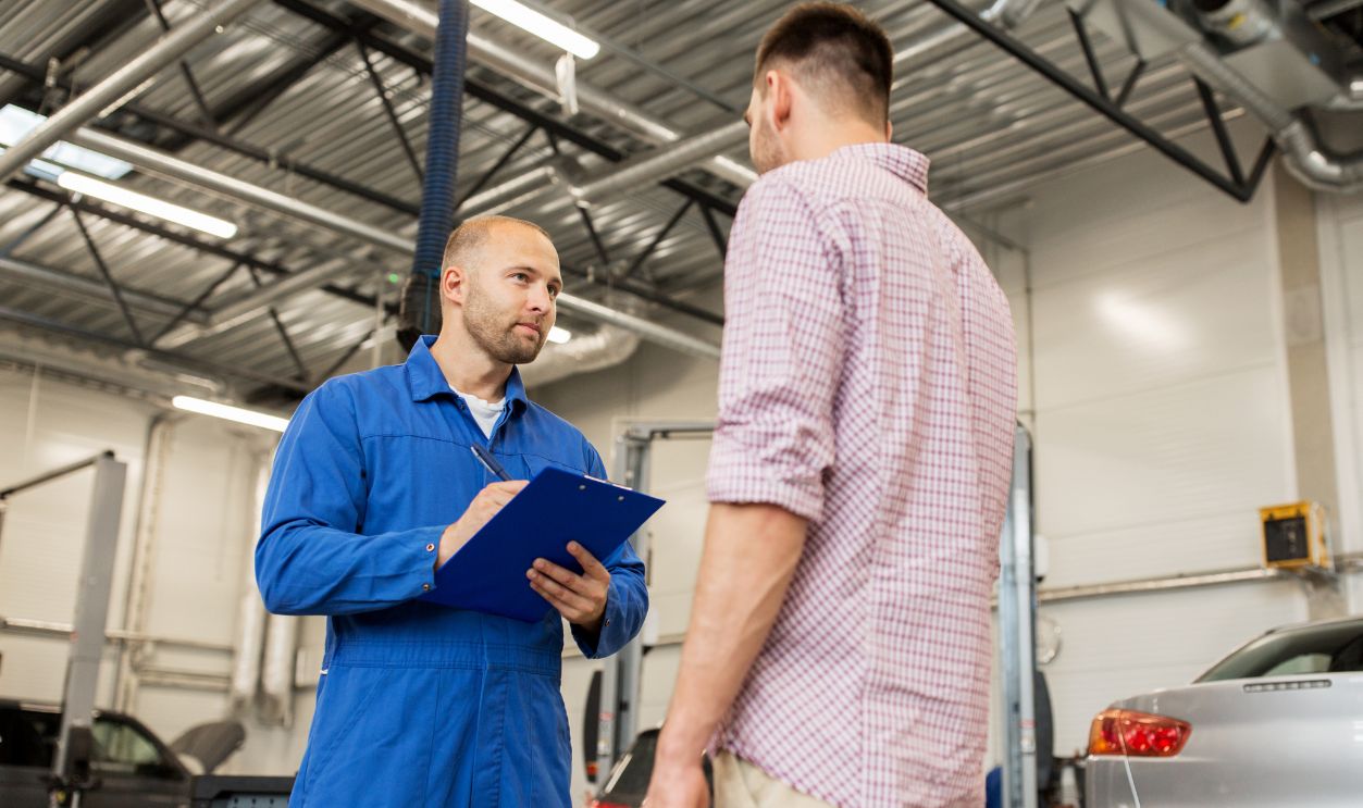 Shutterstock-494861230, auto service, repair, maintenance and people concept - mechanic with clipboard talking to man or owner at car shop