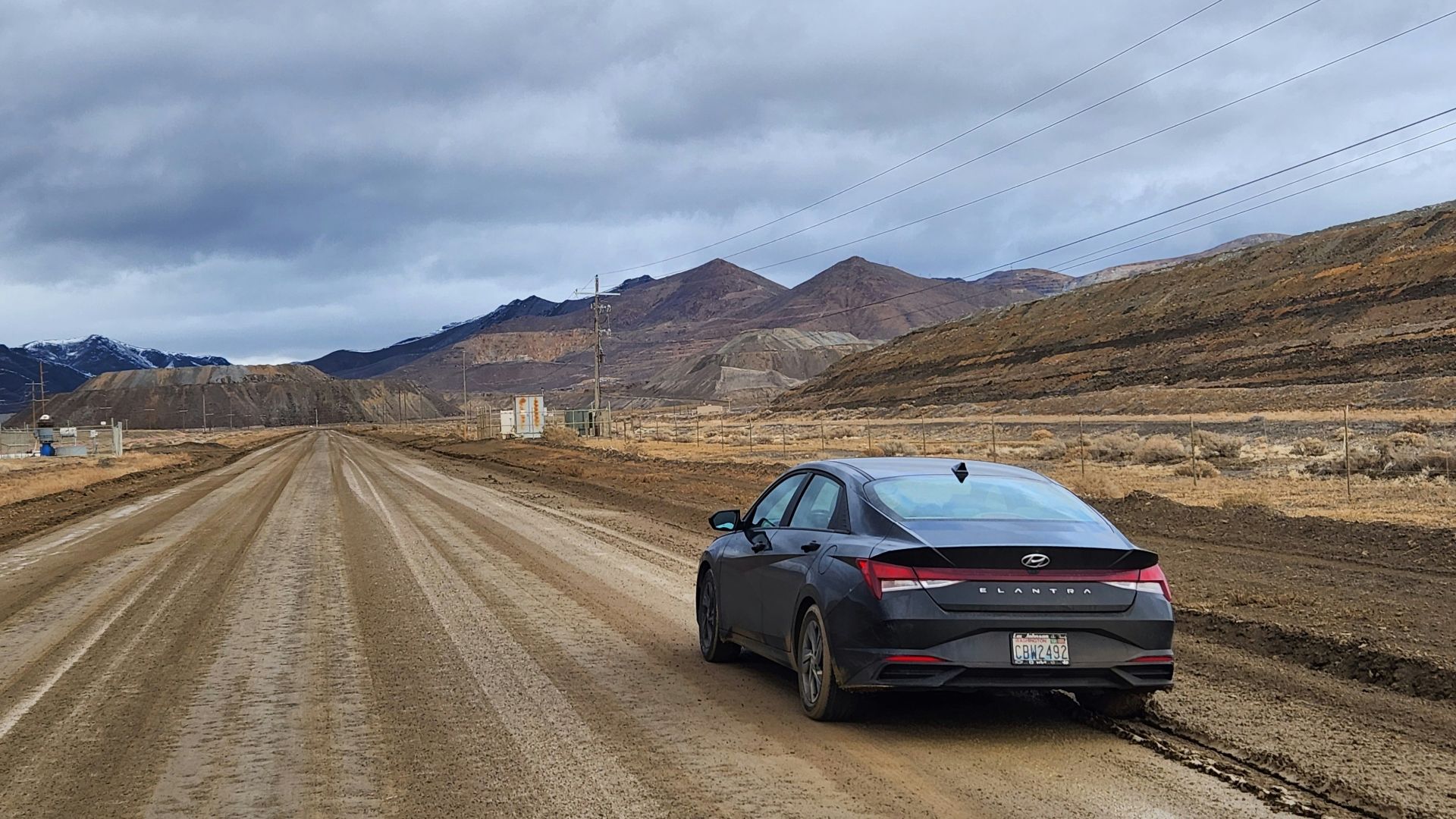 a car parked on a dirt road in the middle of nowhere