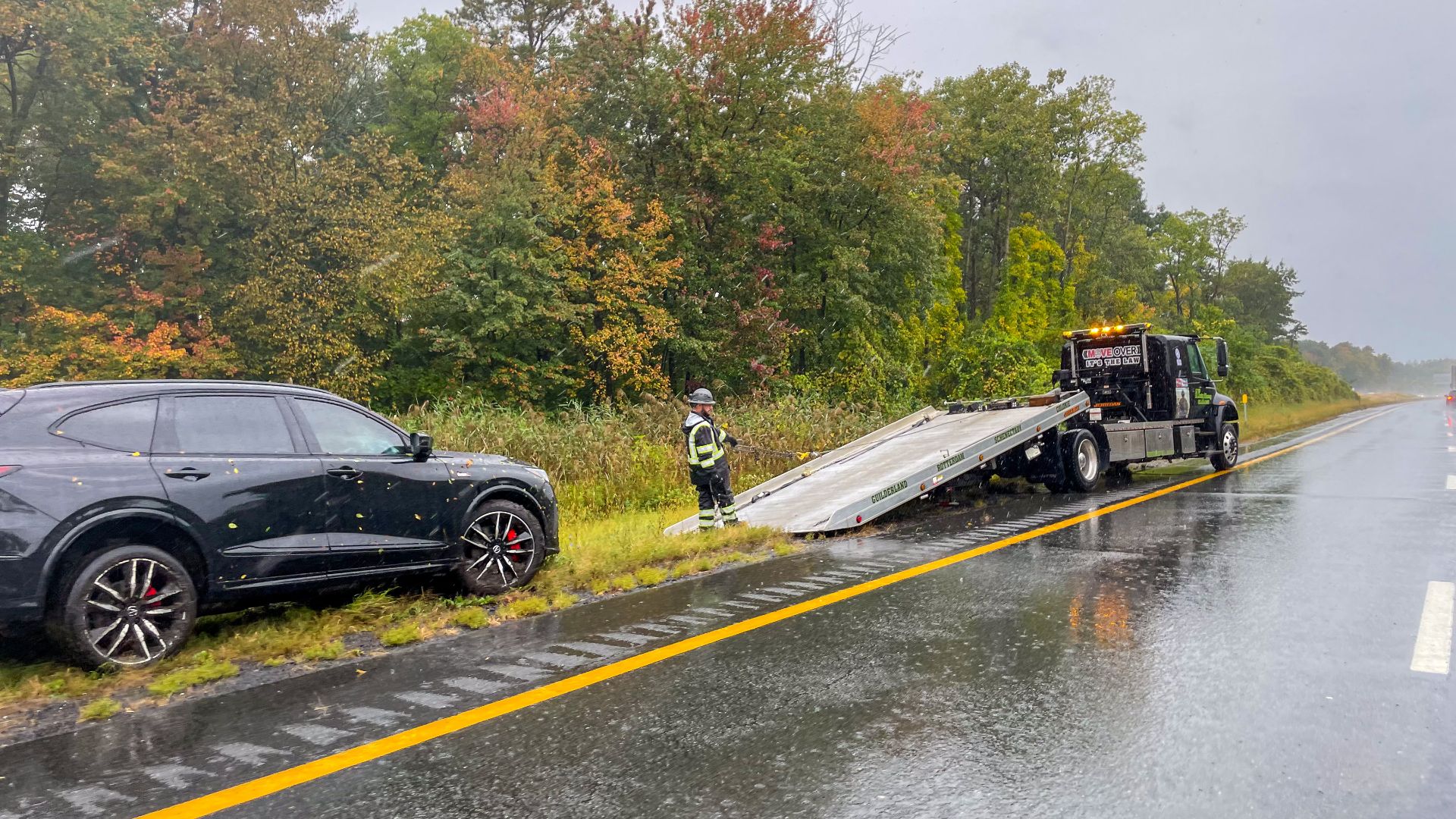 Roadside assistance along I-90 in Albany, New York, during a rainstorm.