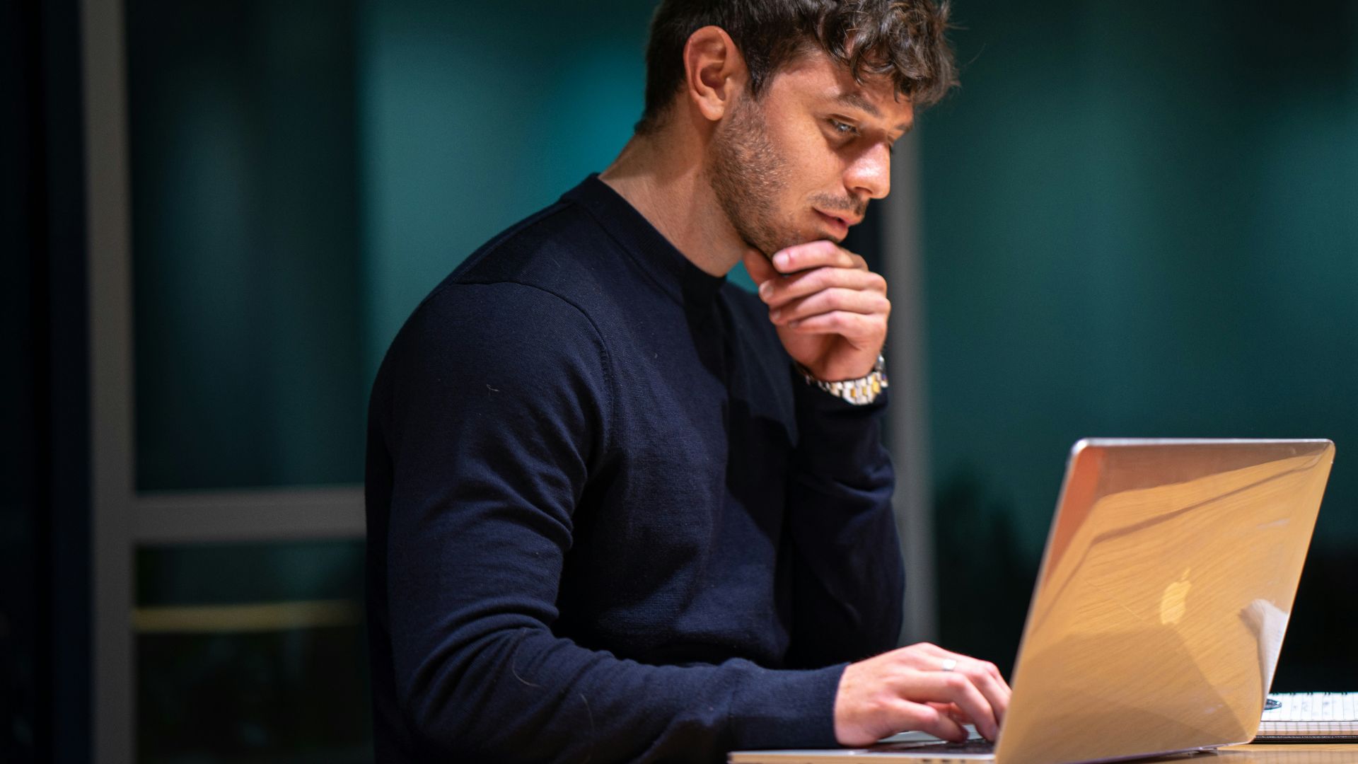 man in black long sleeve shirt sitting in front of macbook