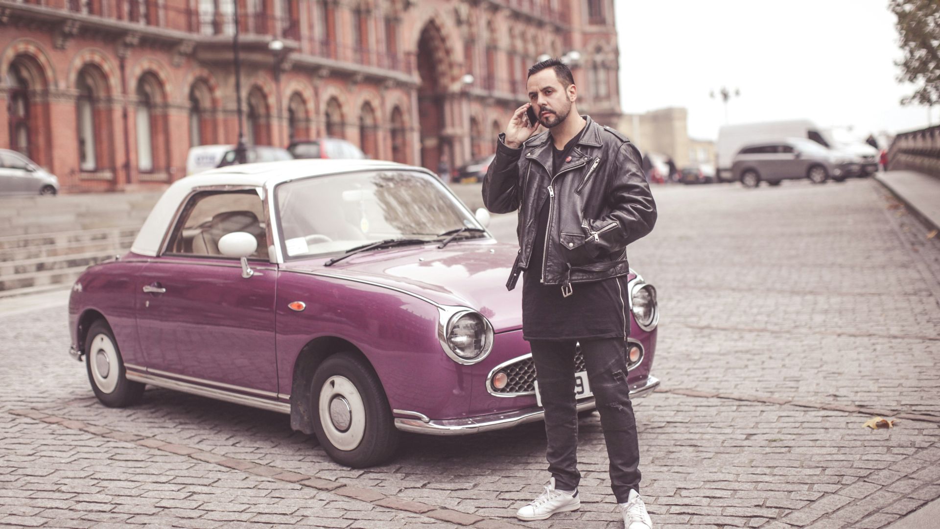 man standing near car beside building