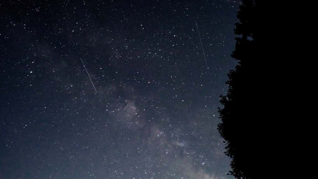 Meteors rip across the night sky in front of the Milky Way