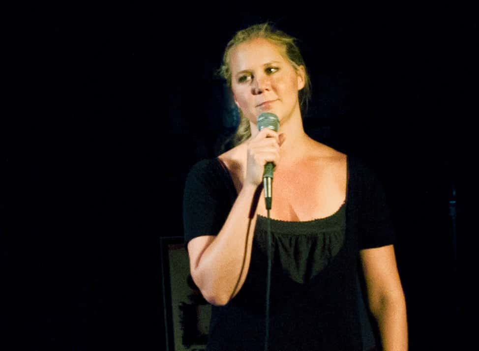 Amy Schumer in black dress on stage
