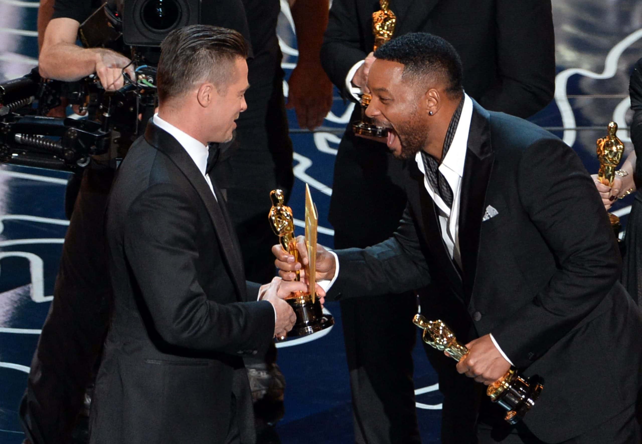Brad Pitt (L) accepts the Best Picture award for '12 Years a Slave' from actor Will Smith