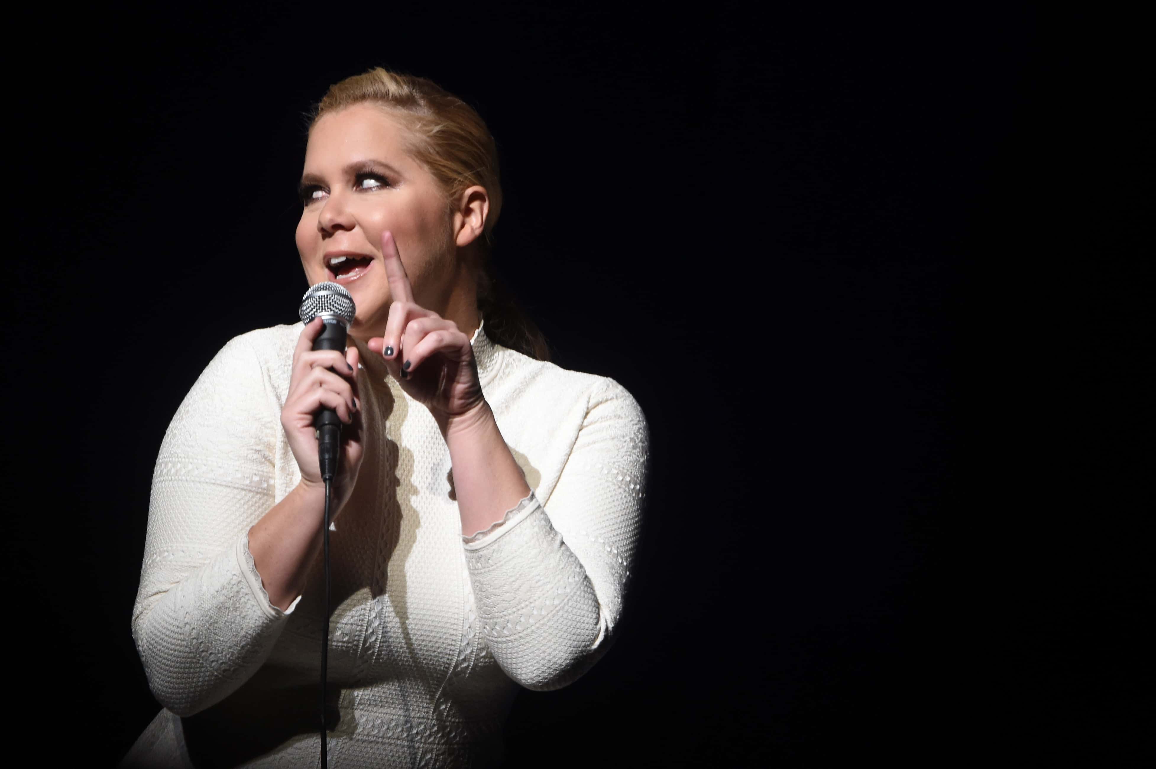 Actress Amy Schumer performs in white dress