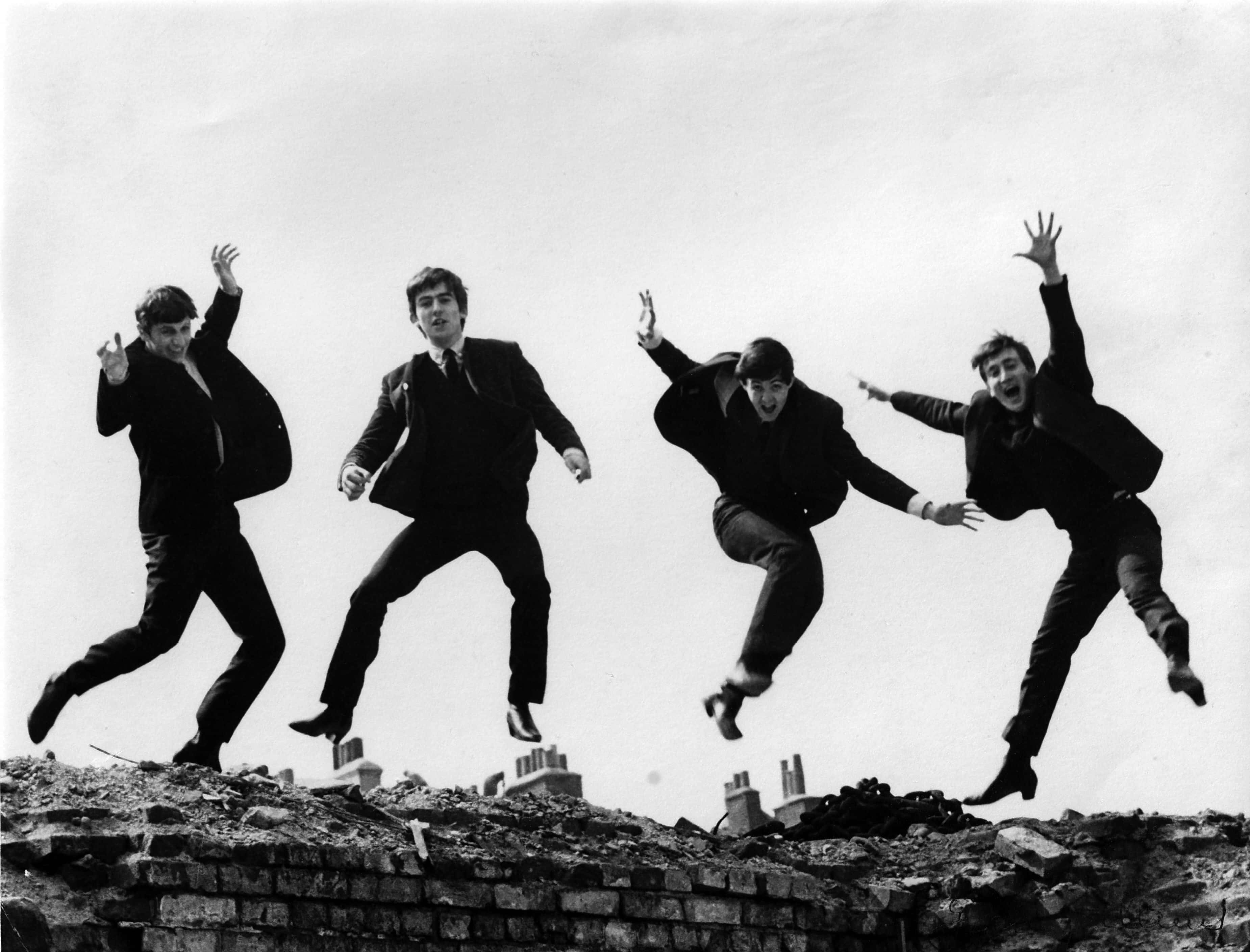 Photo of the Beatles, April 1963  jumping on wall,