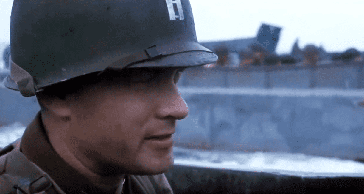 Screenshot of (Tom Hanks) Captain Miller wearing helmet is looking at side - from Saving Private Ryan (1998)