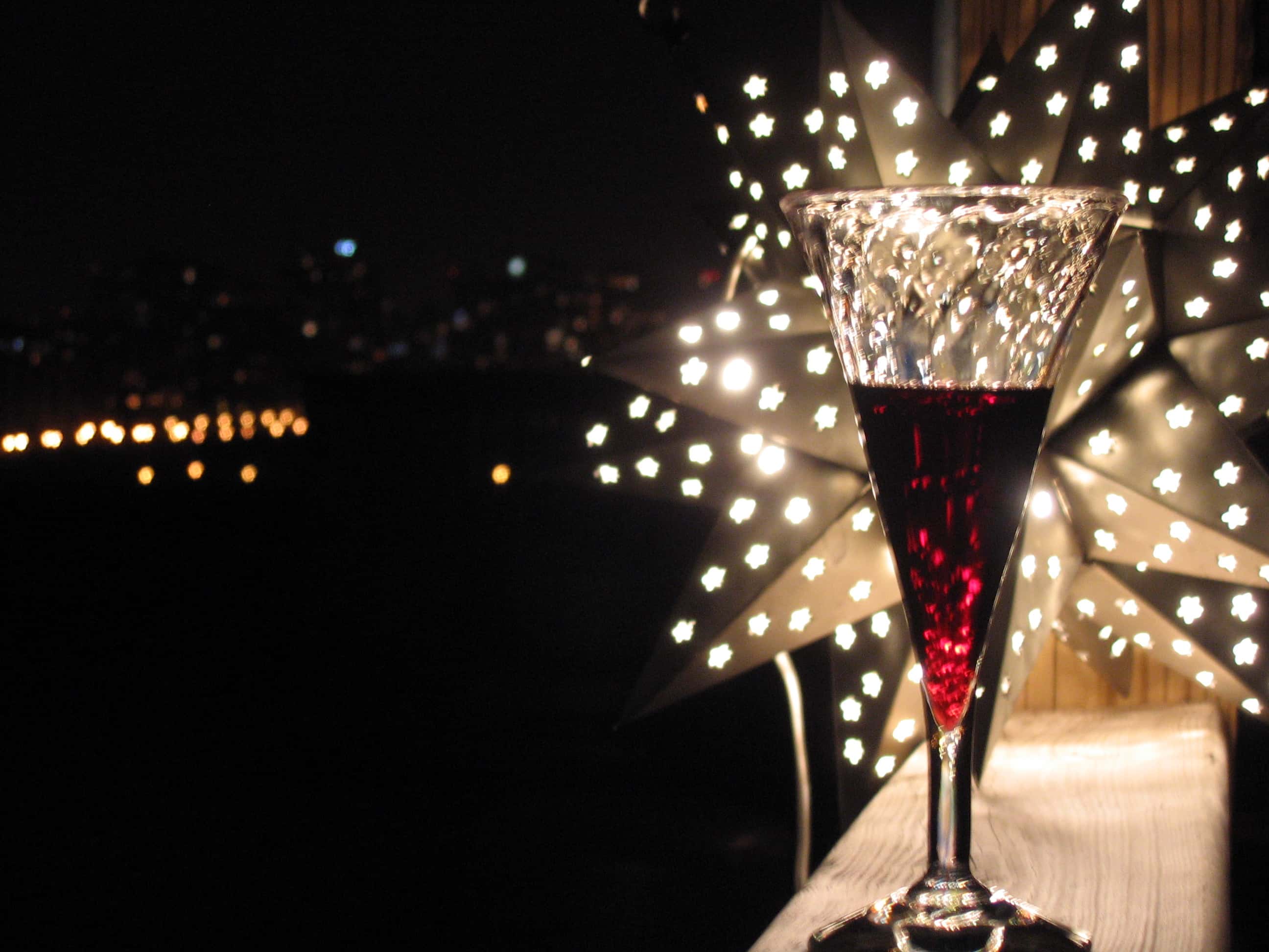 Glass with wine on a wooden platform near a sparkling star