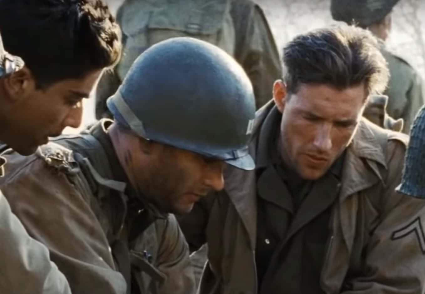 Screenshot of (Tom Hanks) Captain Miller talking with other soldiers - from Saving Private Ryan (1998)