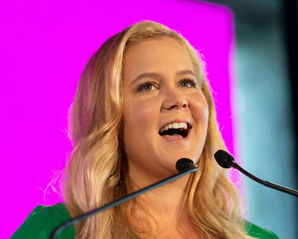 Amy Schumer speaking on stage in green top