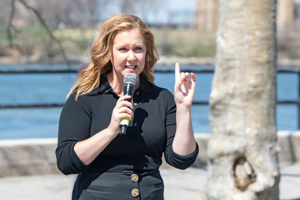 Comedian Amy Schumer performs at a park in black top