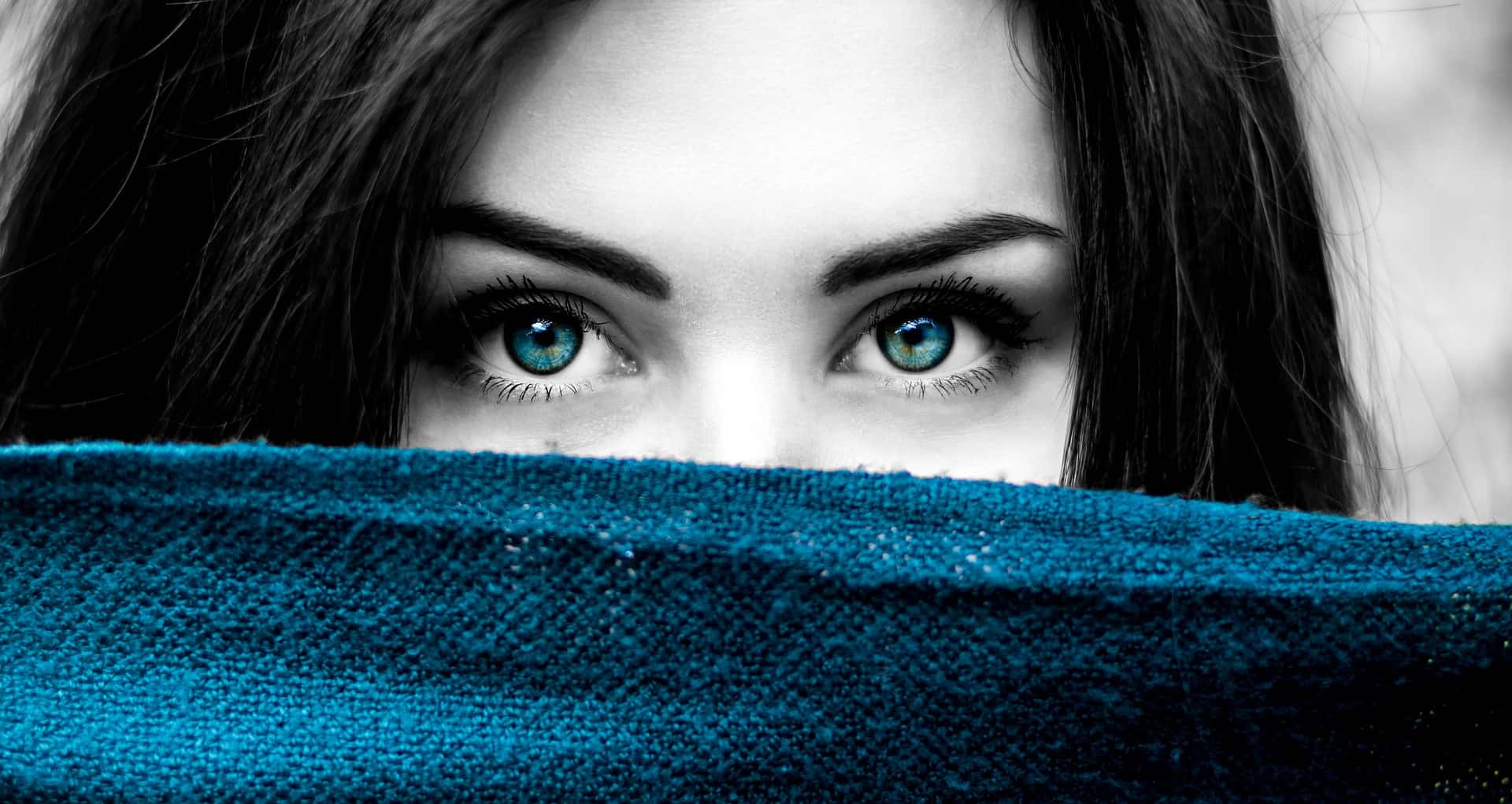 Close up photo of a beautiful young woman with blue eyes and dark hair