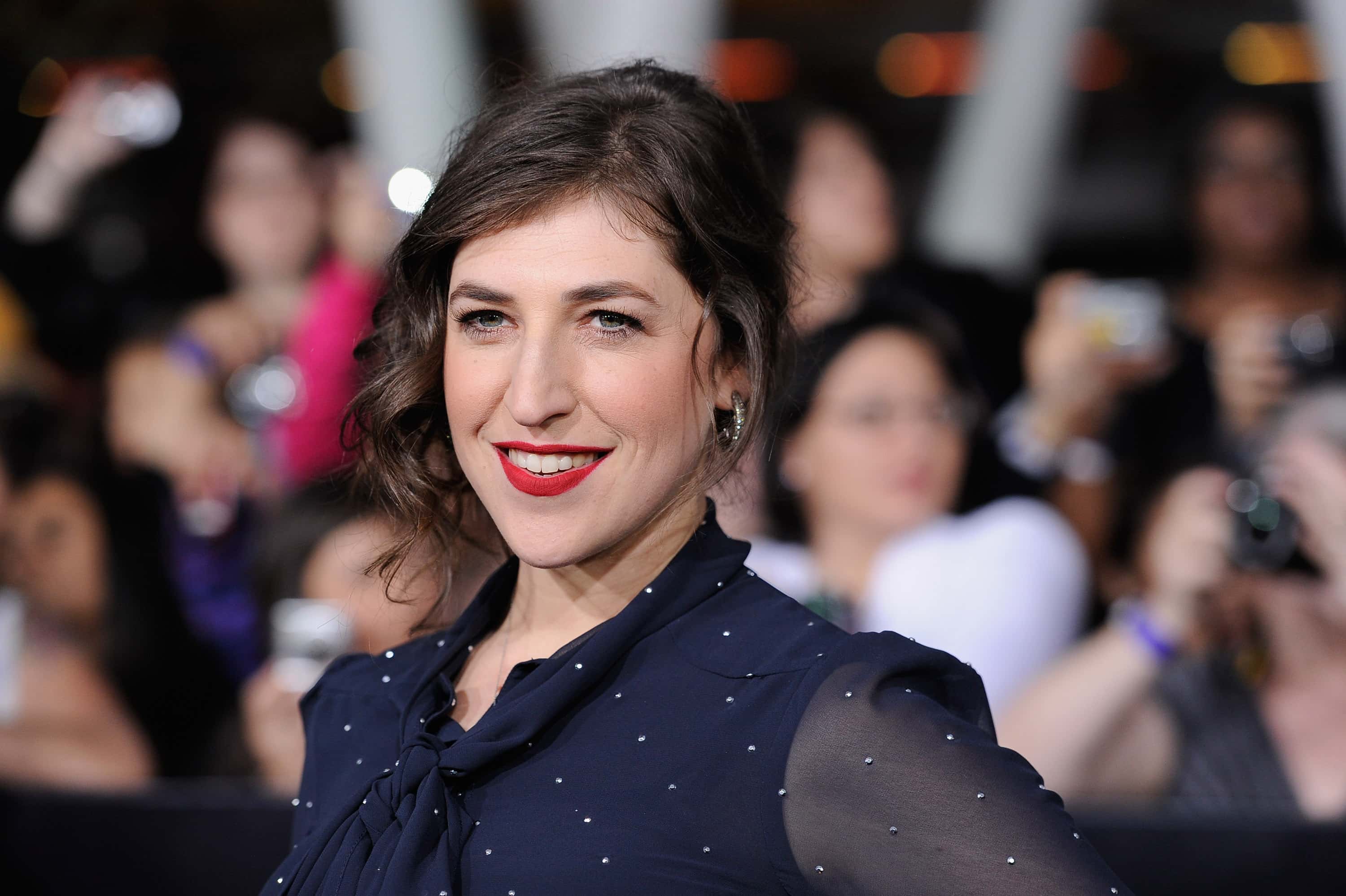 Actress Mayim Bialik arrives at and event in blue dress facing the camera