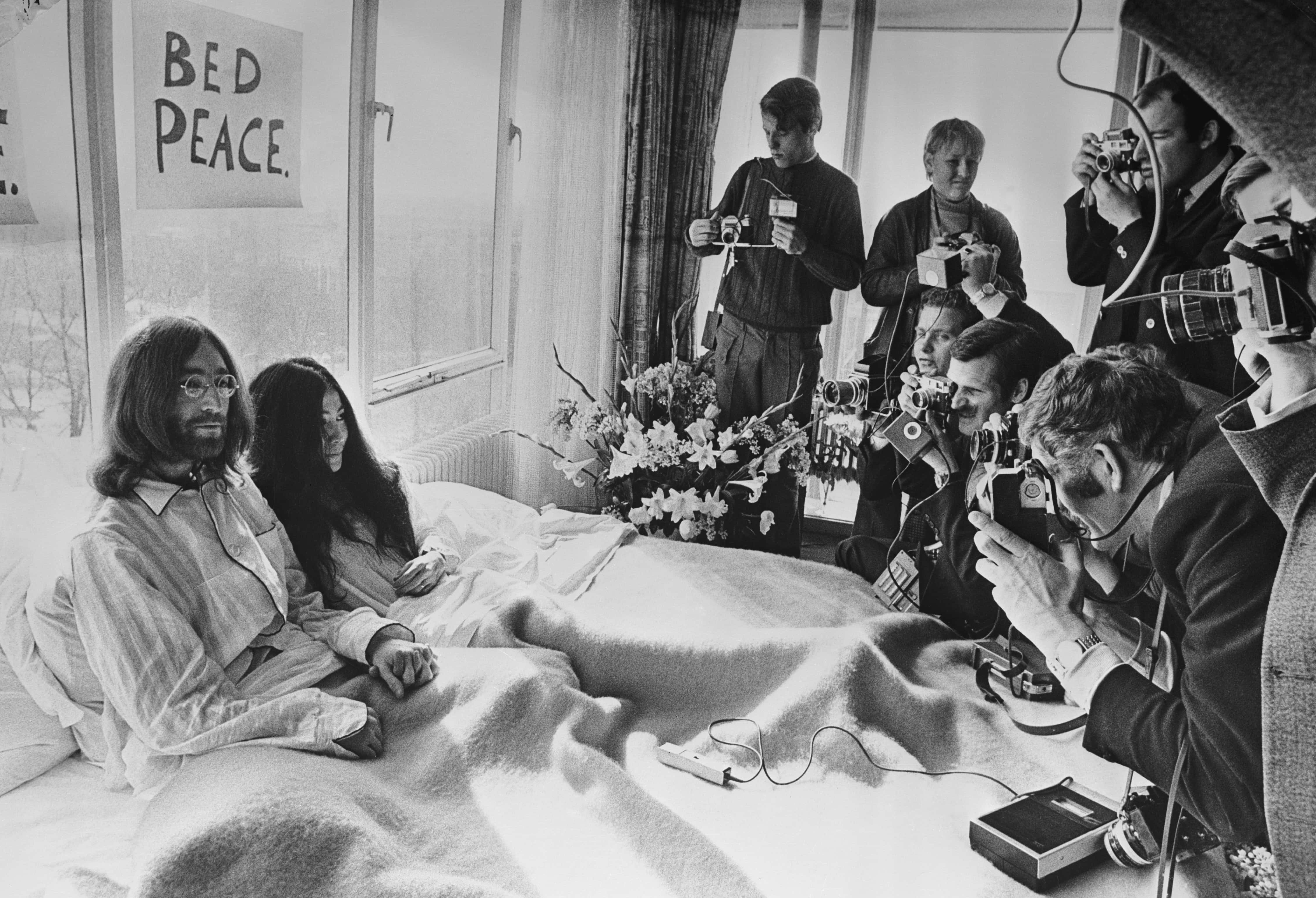 A week after their marriage, musicians John Lennon and Yoko Ono receive the press at their bedside in the Presidential Suite of the Hilton Hotel, Amsterdam.