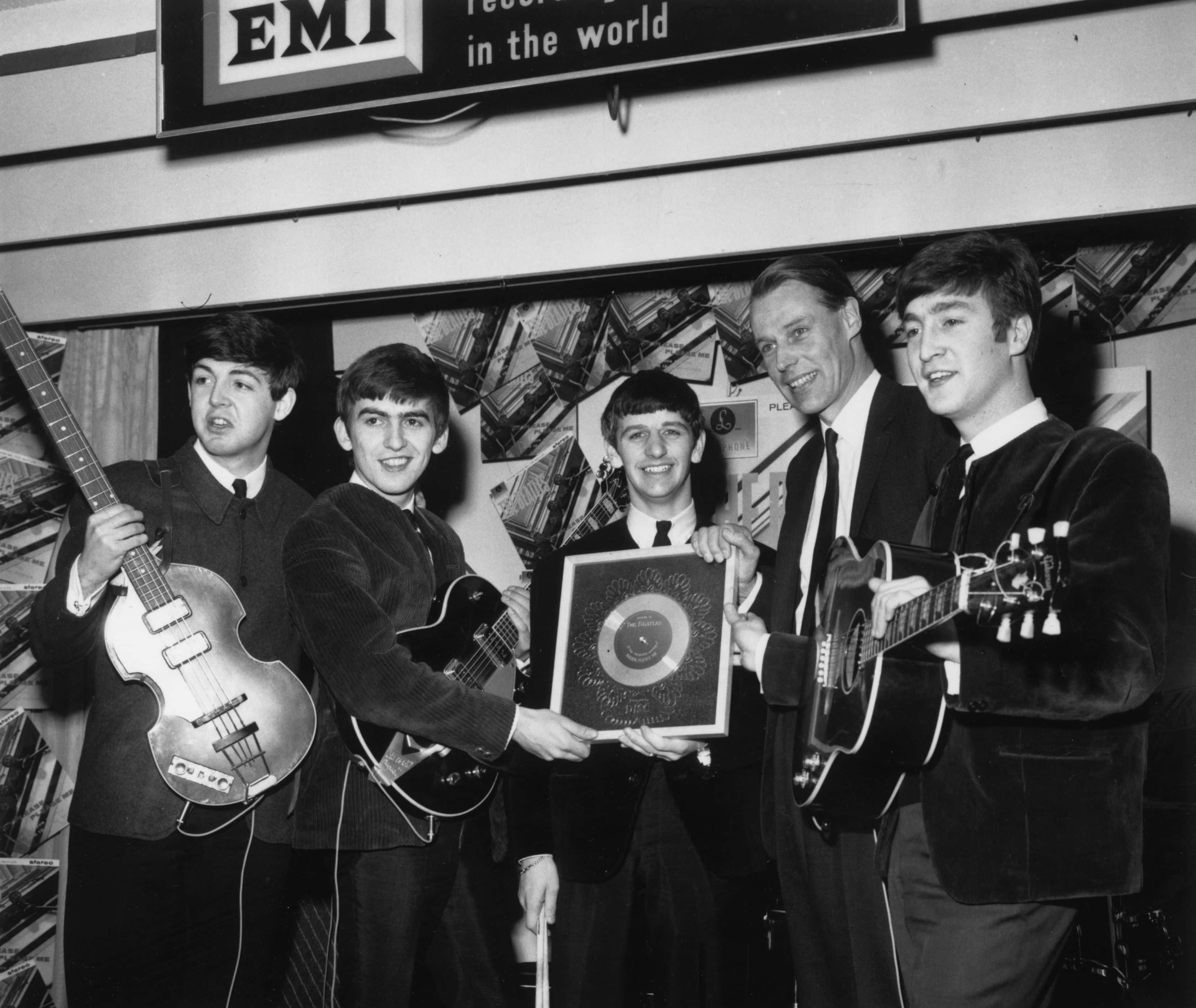 British pop group The Beatles holding their silver disc.