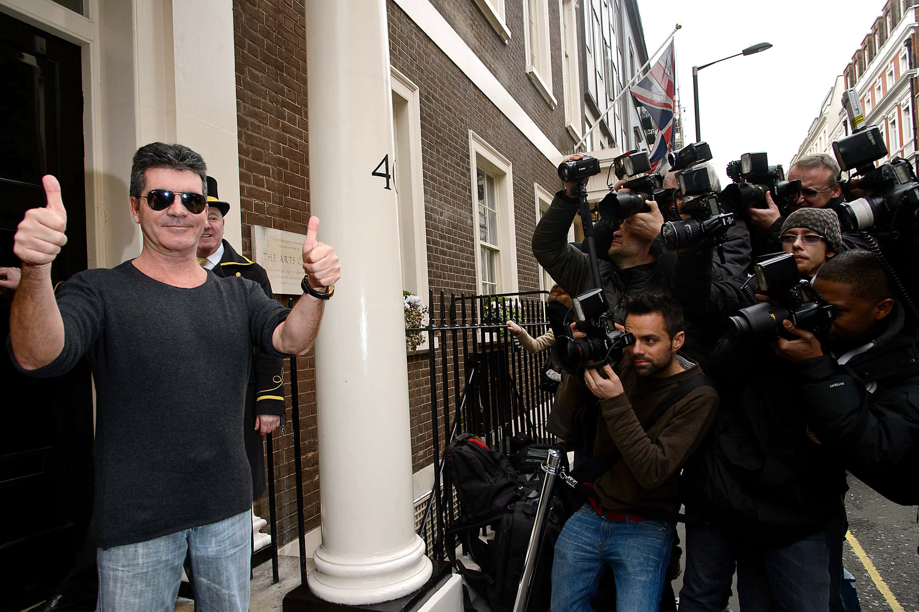Simon Cowell in black t-shirt in front of press 