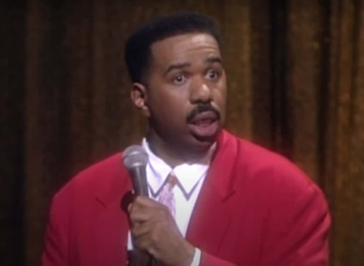 Screenshot of  Steve Harvey wearing pink jacket and looking at side - from The Steve Harvey Show (1996/2002)