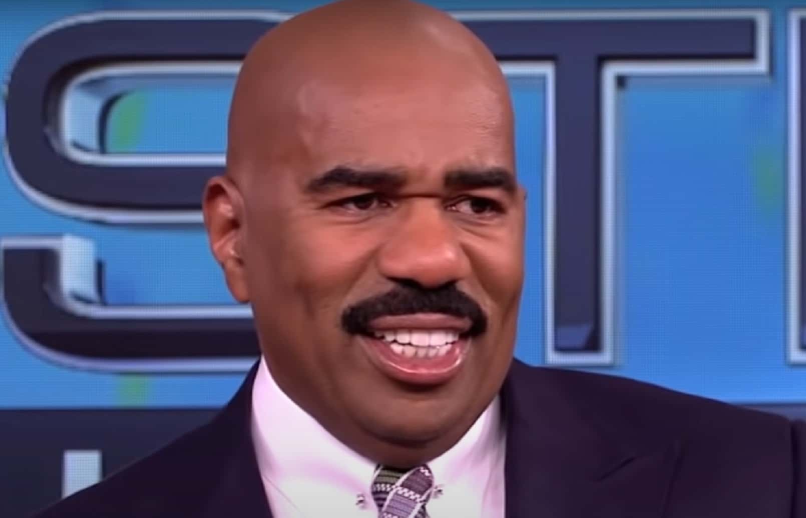 Screenshot of Steve Harvey looking at side and smiling - from Steve Harvey (2012/2017)