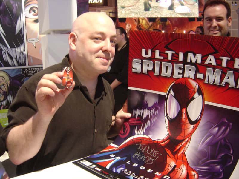 Brian Michael Bendis posing with a figurine 