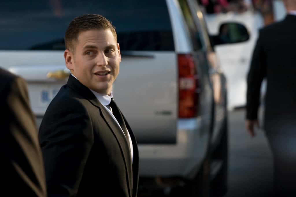 Jonah Hill in suit looking at side.