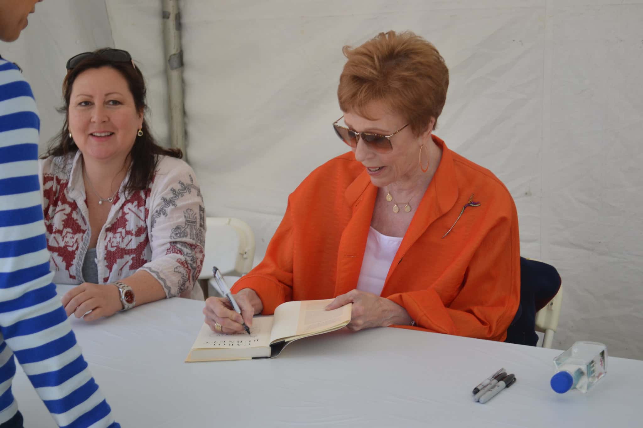 Image of Carol Burnett signing a book.