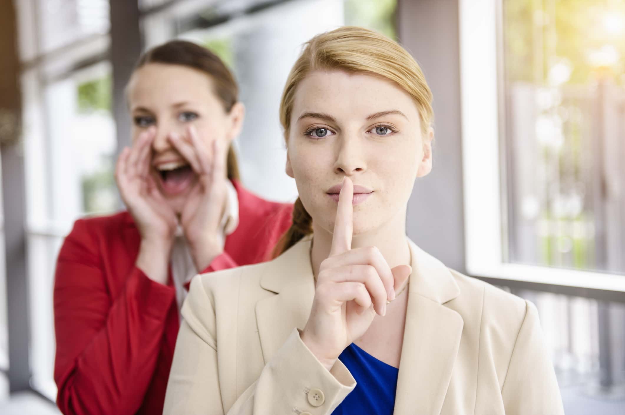 Businesswomen hiding and letting out secret.