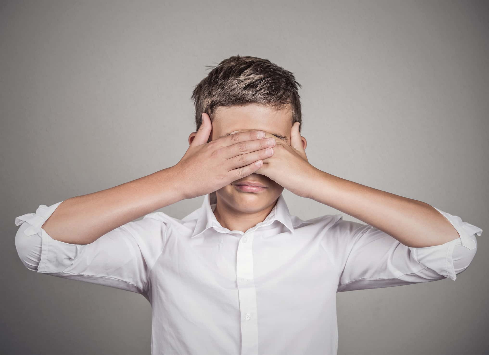 Shy kid covering eyes with hands