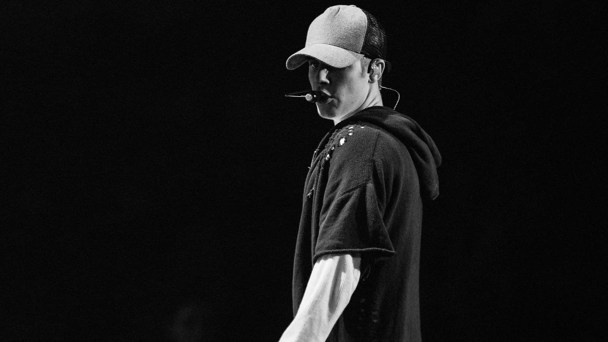 Justin Bieber in dark outfit, performing on stage