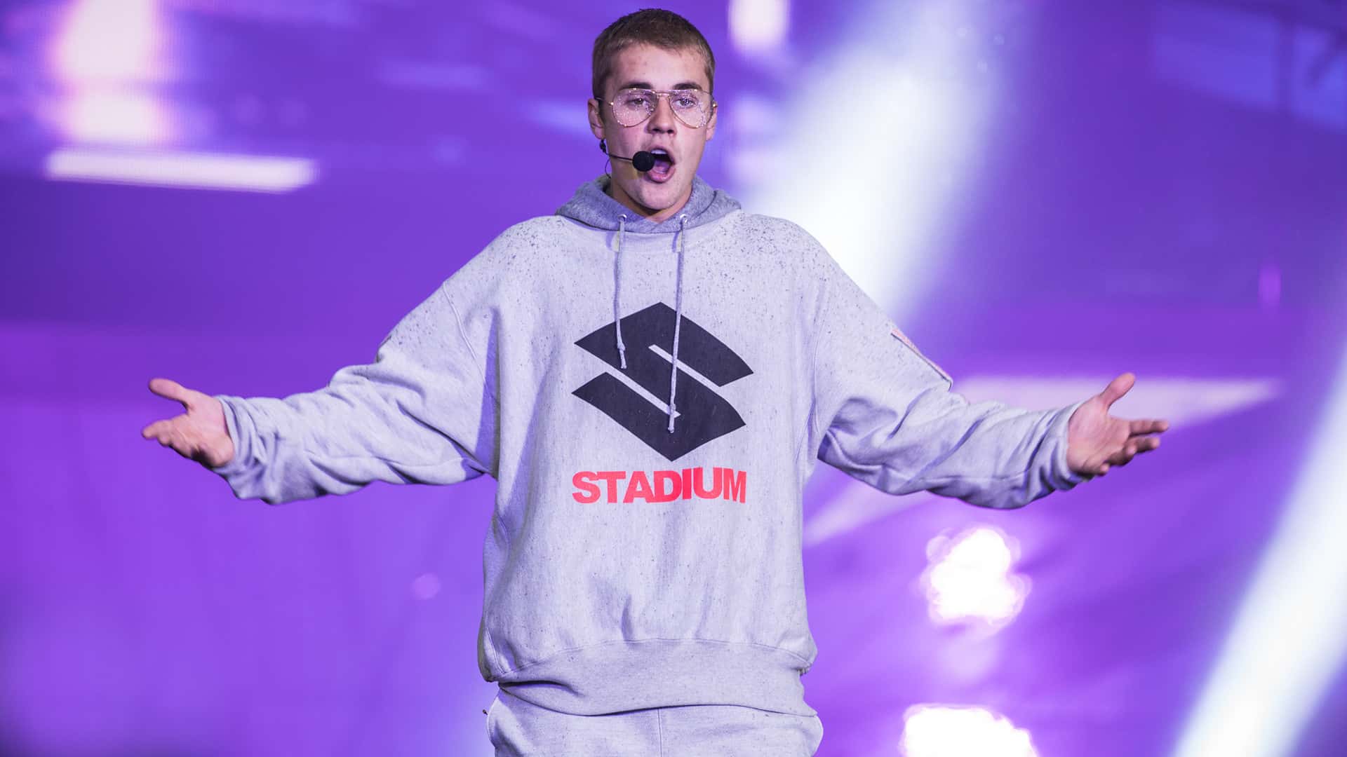 Justin Bieber in gray outfit, performing on stage