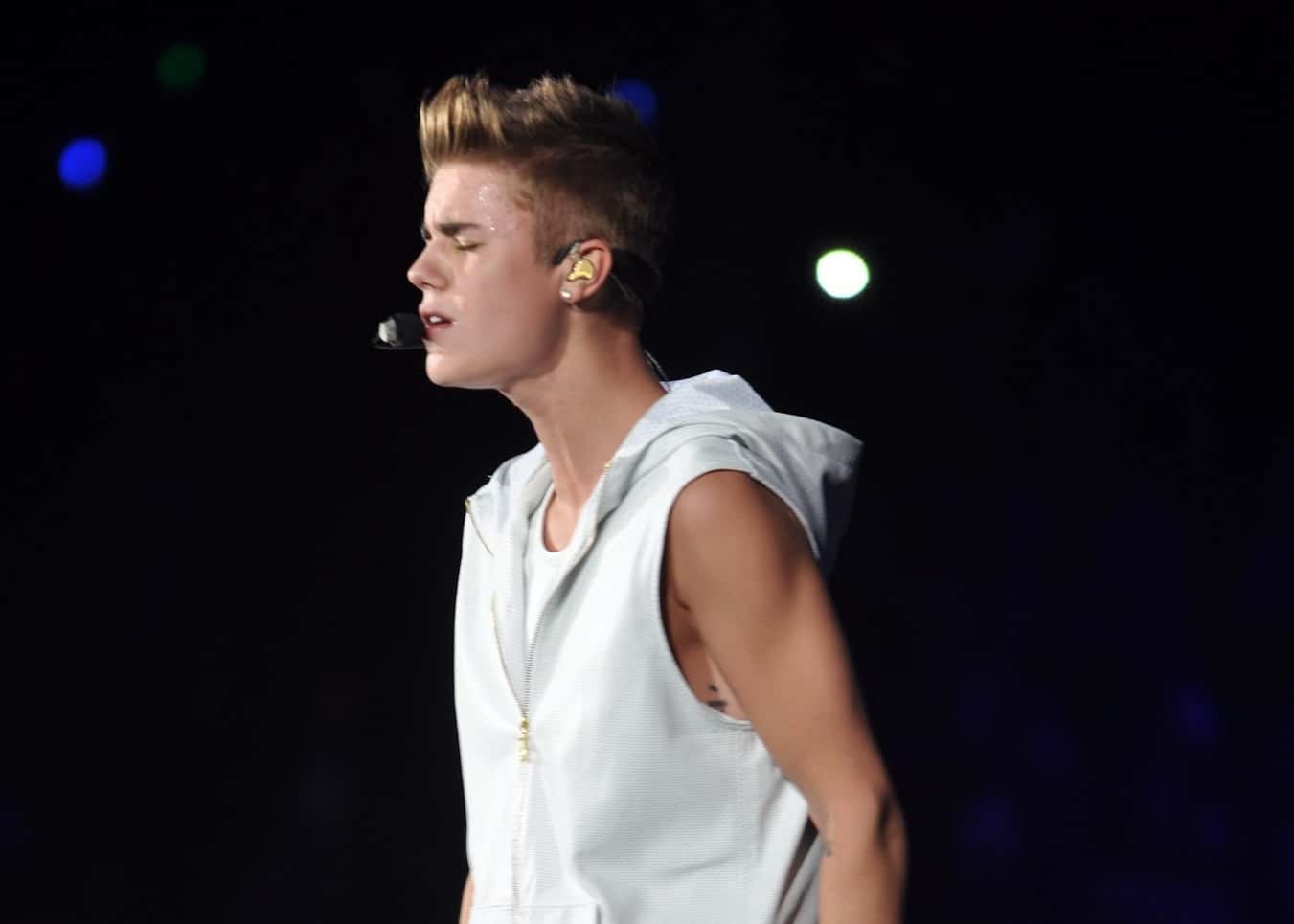 Justin Bieber in white outfit, performing on stage