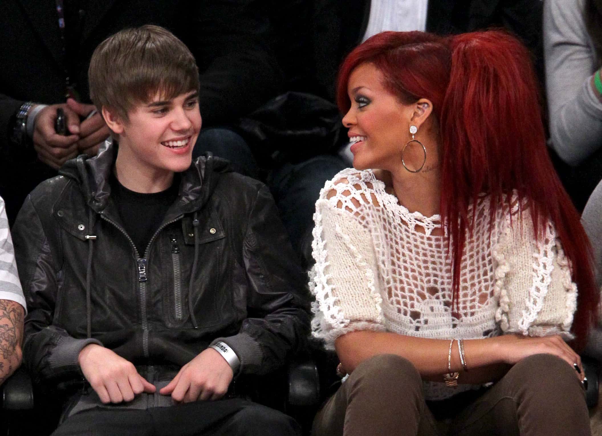 Singers Justin Bieber (L) and Rihanna sit in the audience during the 2011 NBA All-Star game