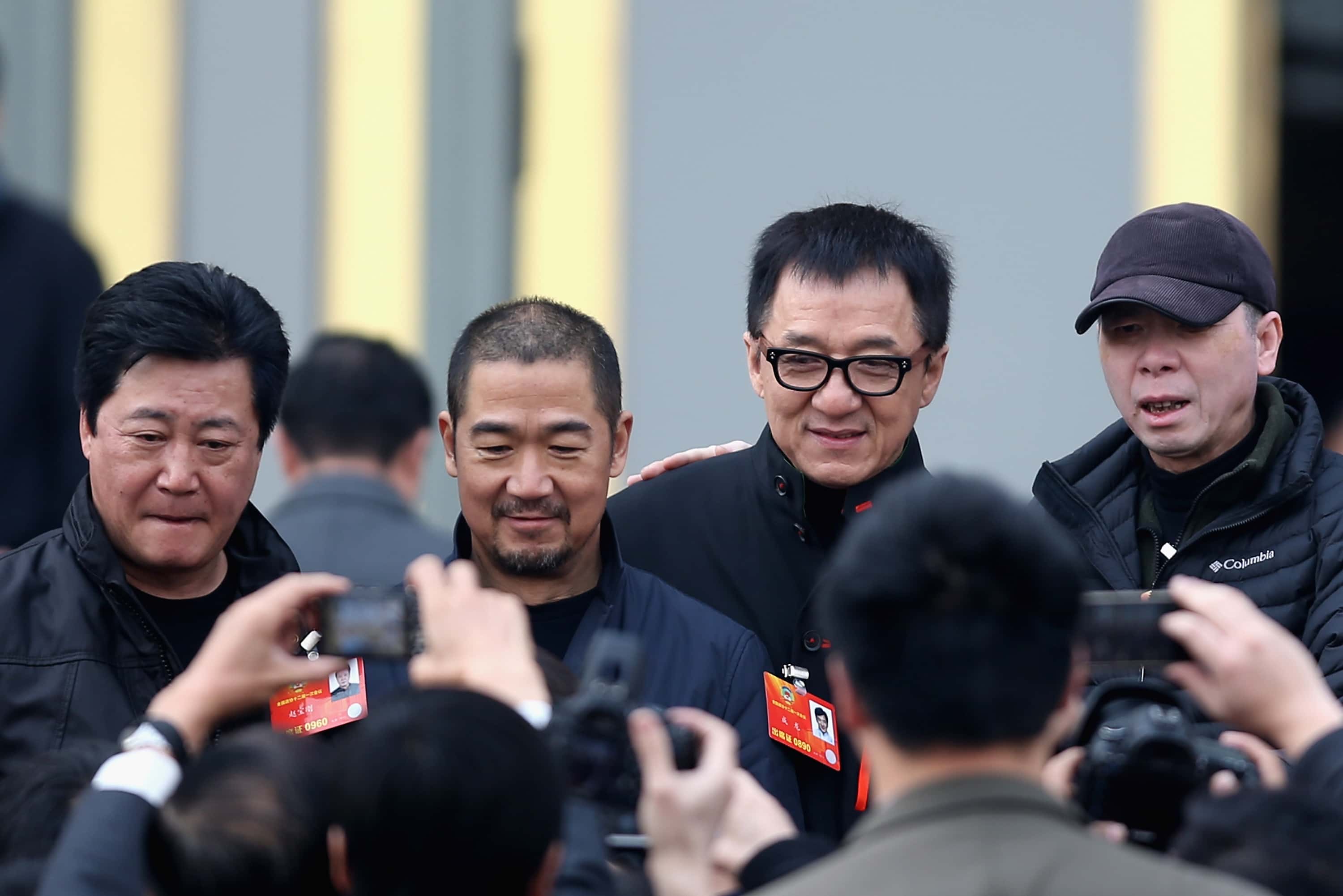 Hong Kong actor Jackie Chan (2nd R), Chinese actor Zhang Guoli (2nd L), Chinese director Feng Xiaogang (R) and Chinese director Zhao Baogang (L) arrive at a plenary session of the Chinese People's Political Consultative Conference