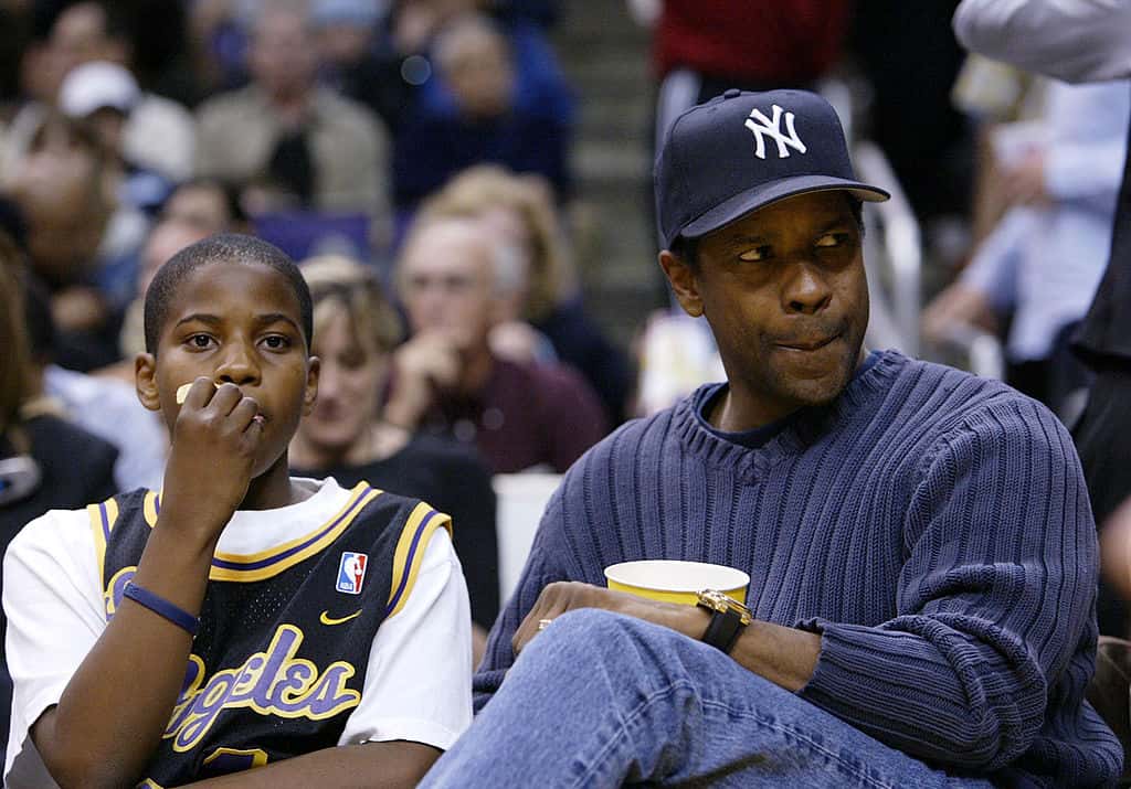 Actor Denzel Washington (R) and his son attend the game between the Los Angeles Lakers and the Minnesota Timberwolves
