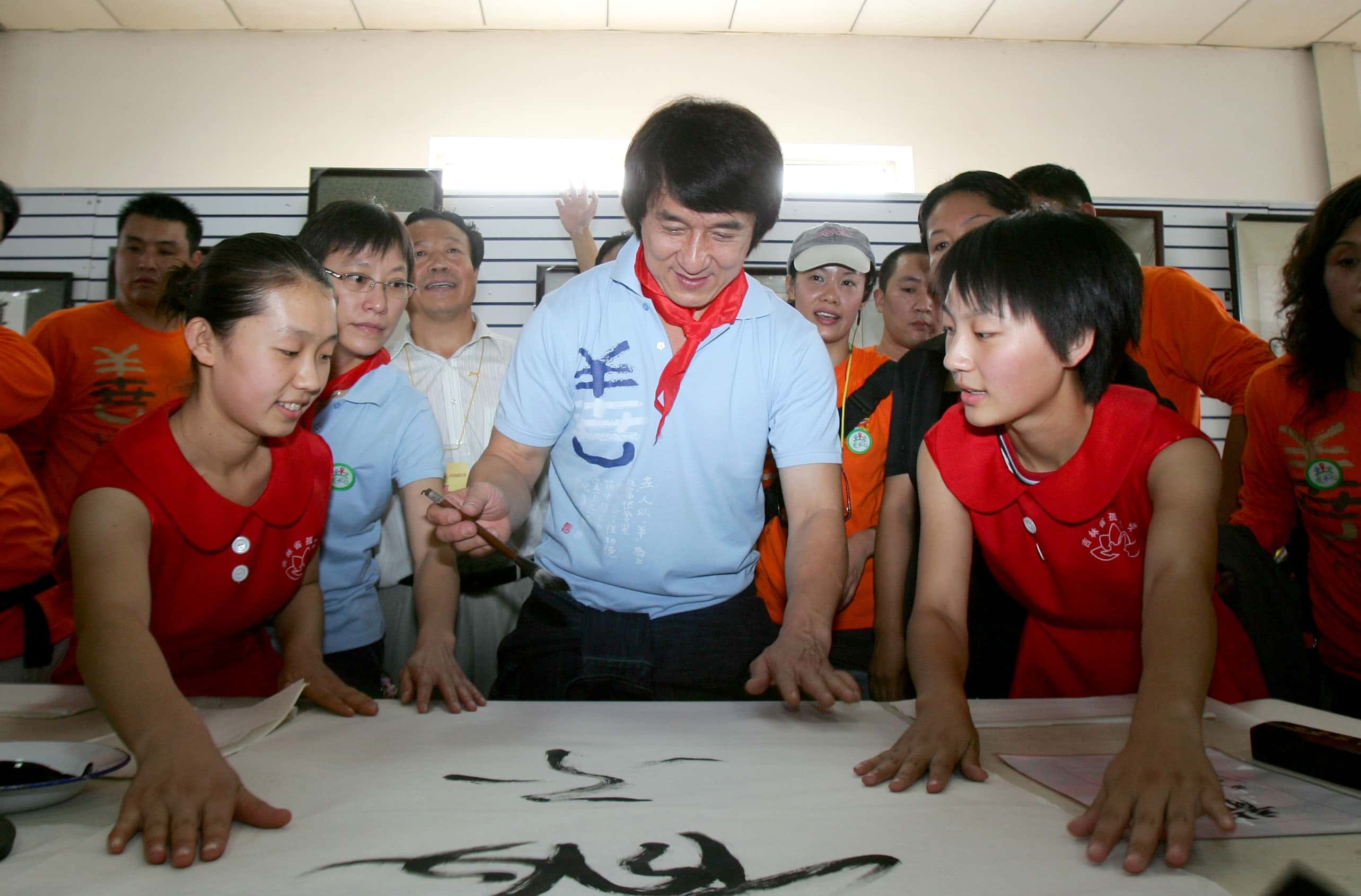 Hong Kong action star Jackie Chan (C) writes for the Jilin Provincial Orphan School on September 16, 2007 in Changchun of Jilin Province, China.