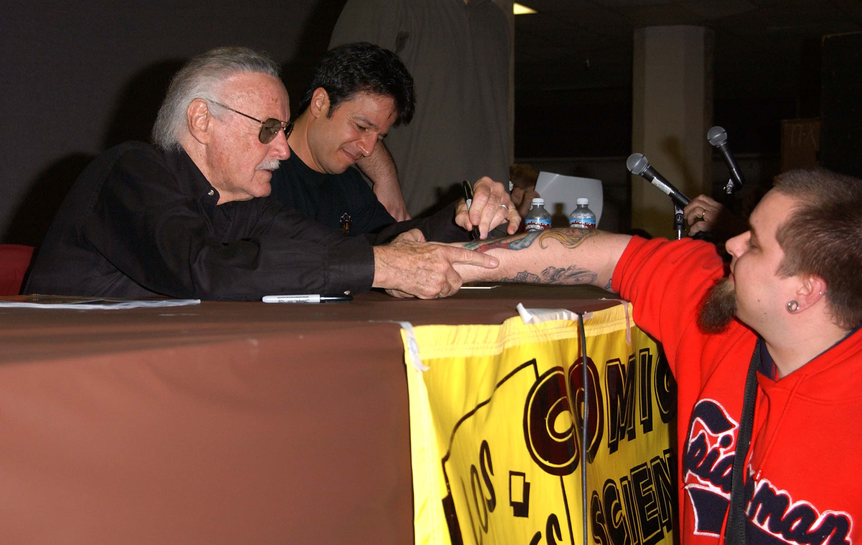 Spider-Man creator Stan Lee autographs a fan's tattoo