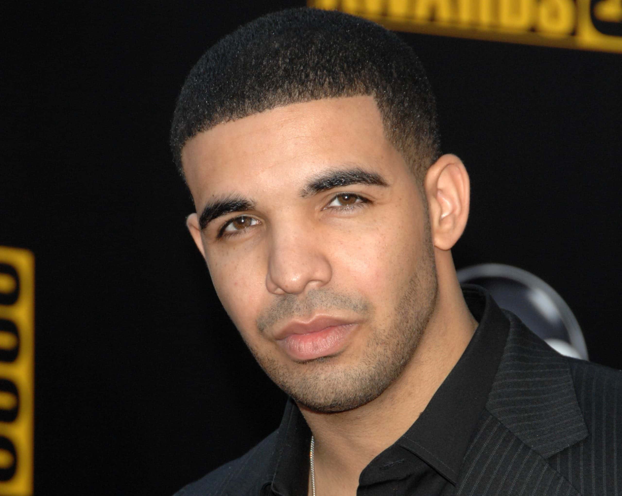 Drake dressed in a black suit