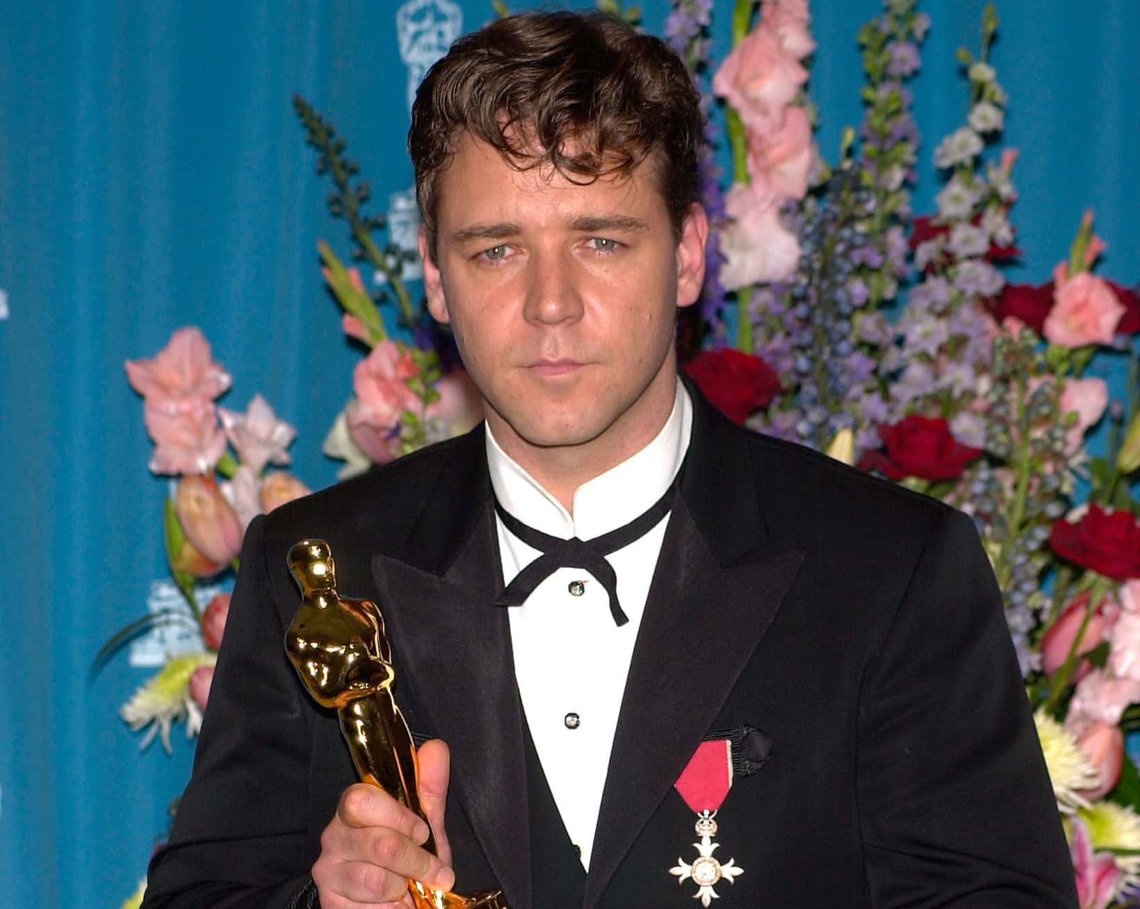 Russell Crowe posing with an Oscar award