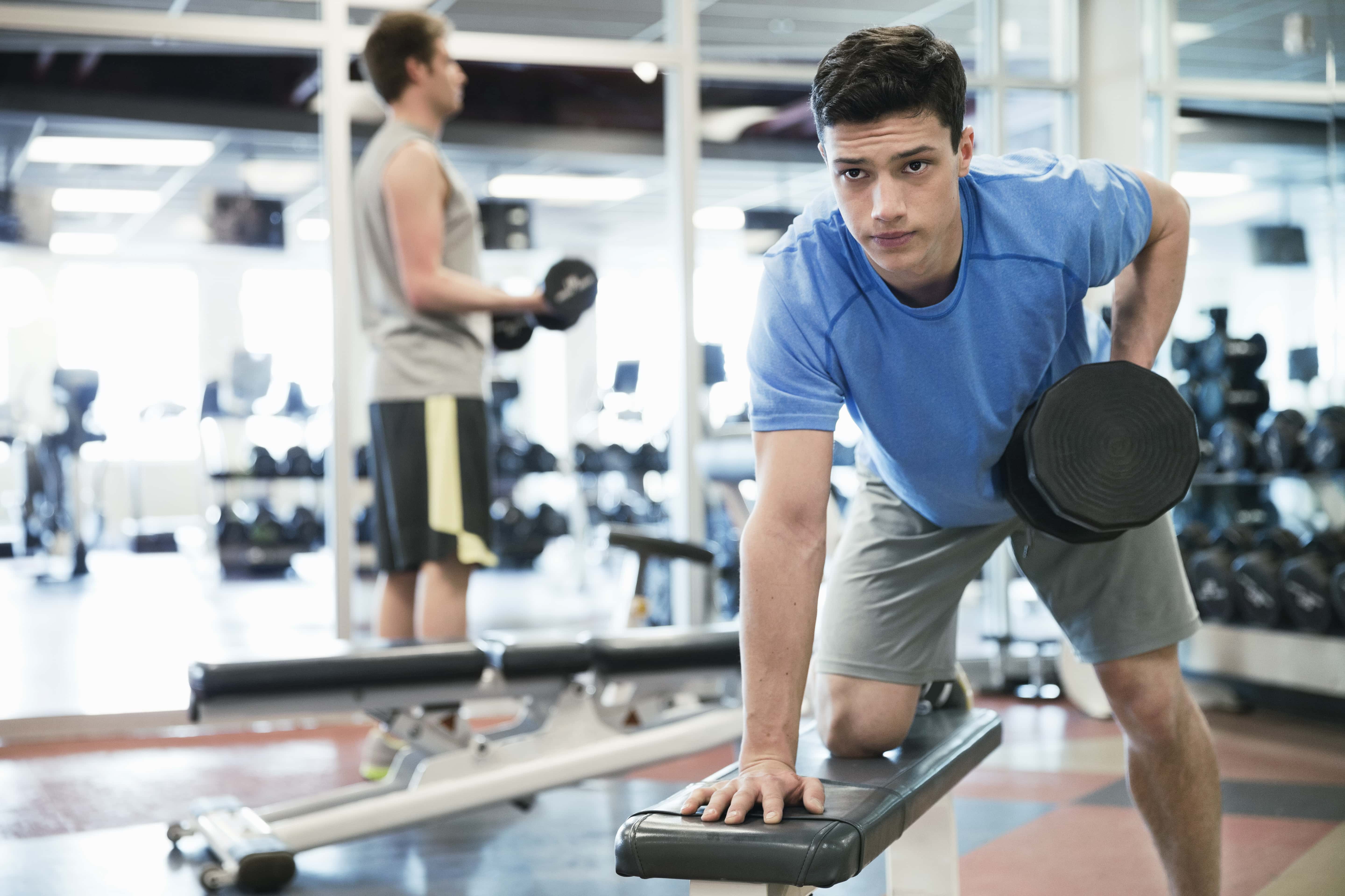 Man lifting weights in fitness center.