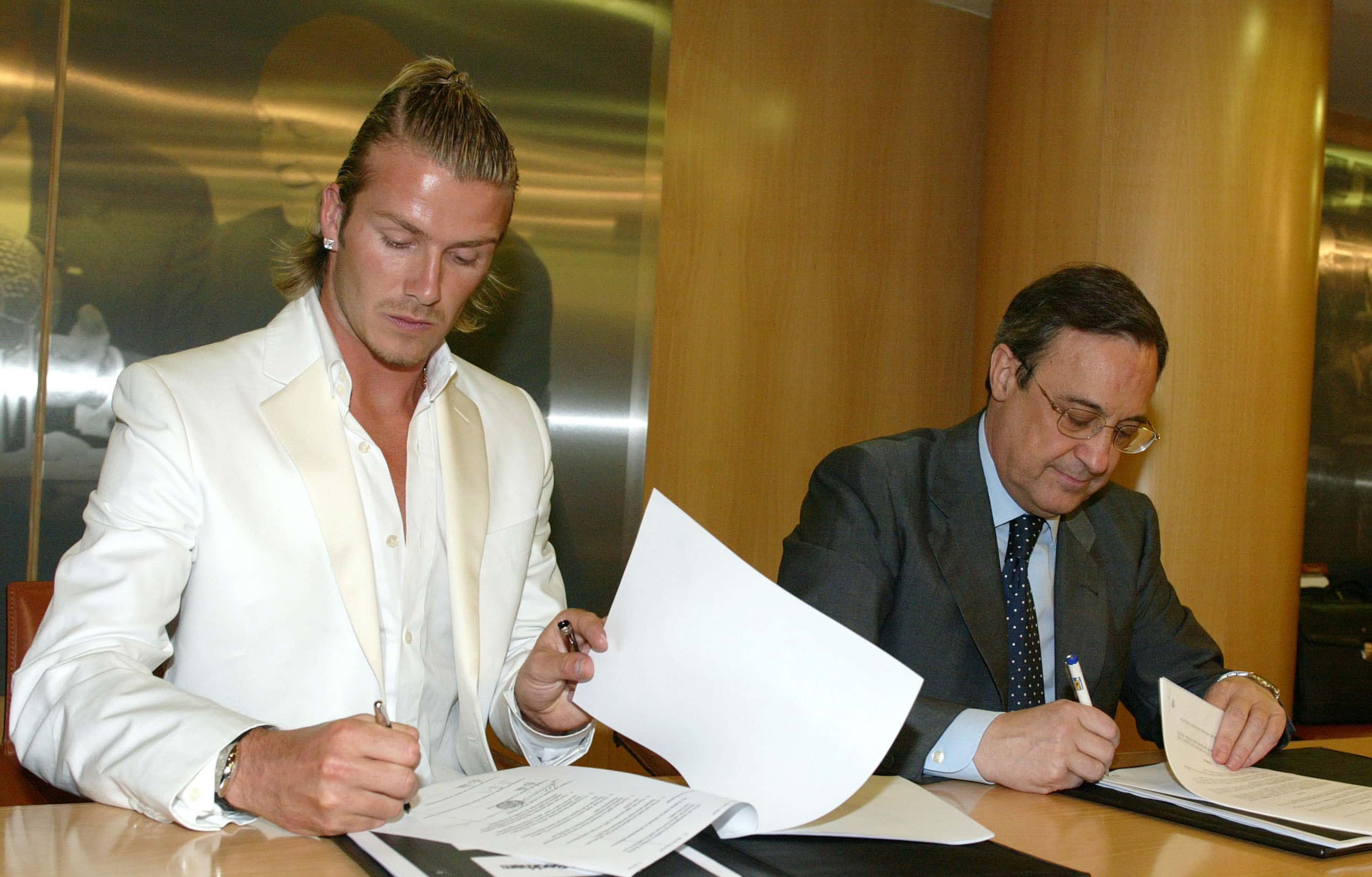 David Beckham (L) signs papers with Real Madrid President Florentino Perez at Santiago Bernabeu Stadium July 1, 2003 in Madrid, Spain