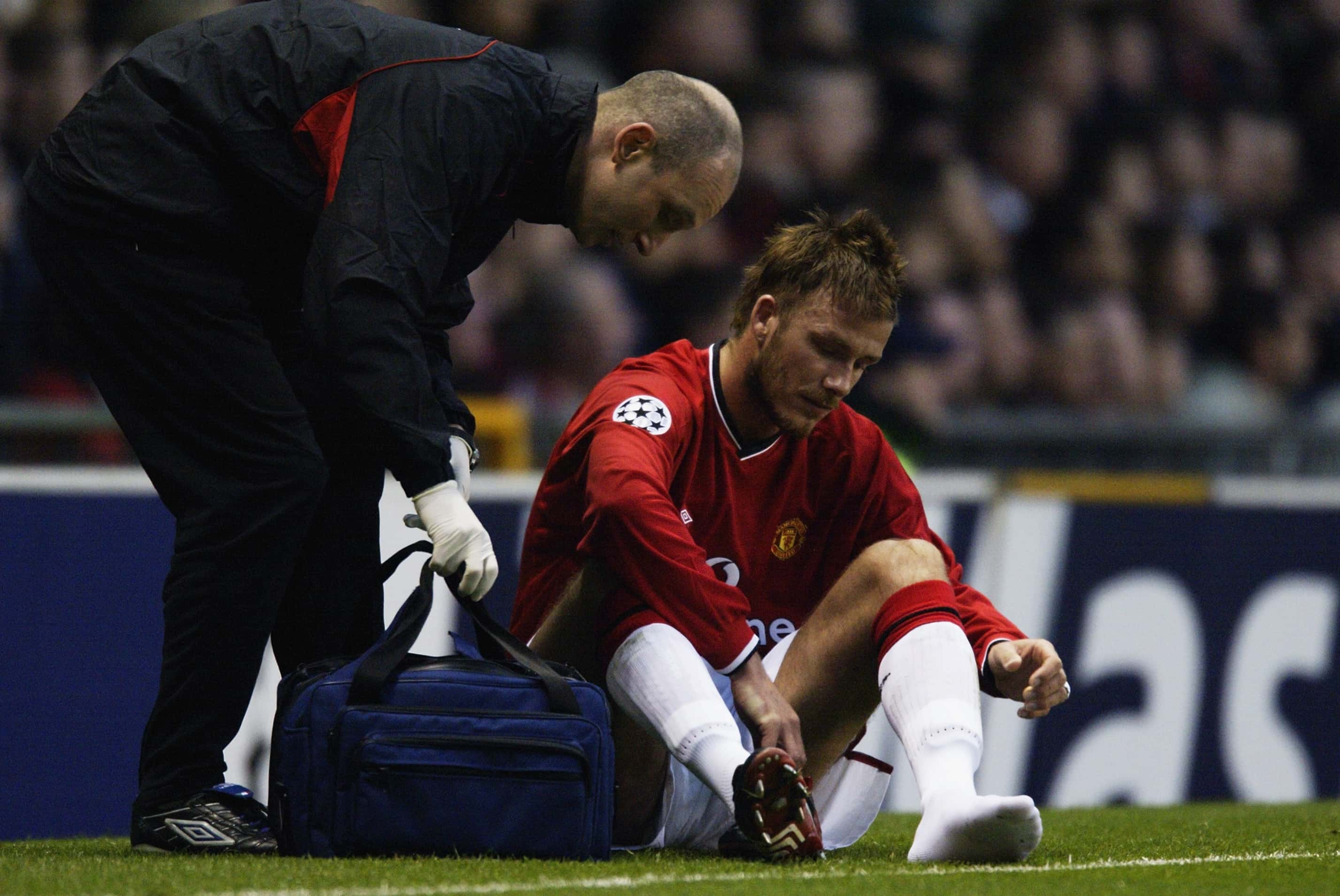 David Beckham of Manchester United looks at the damaged foot after picking up a serious injury