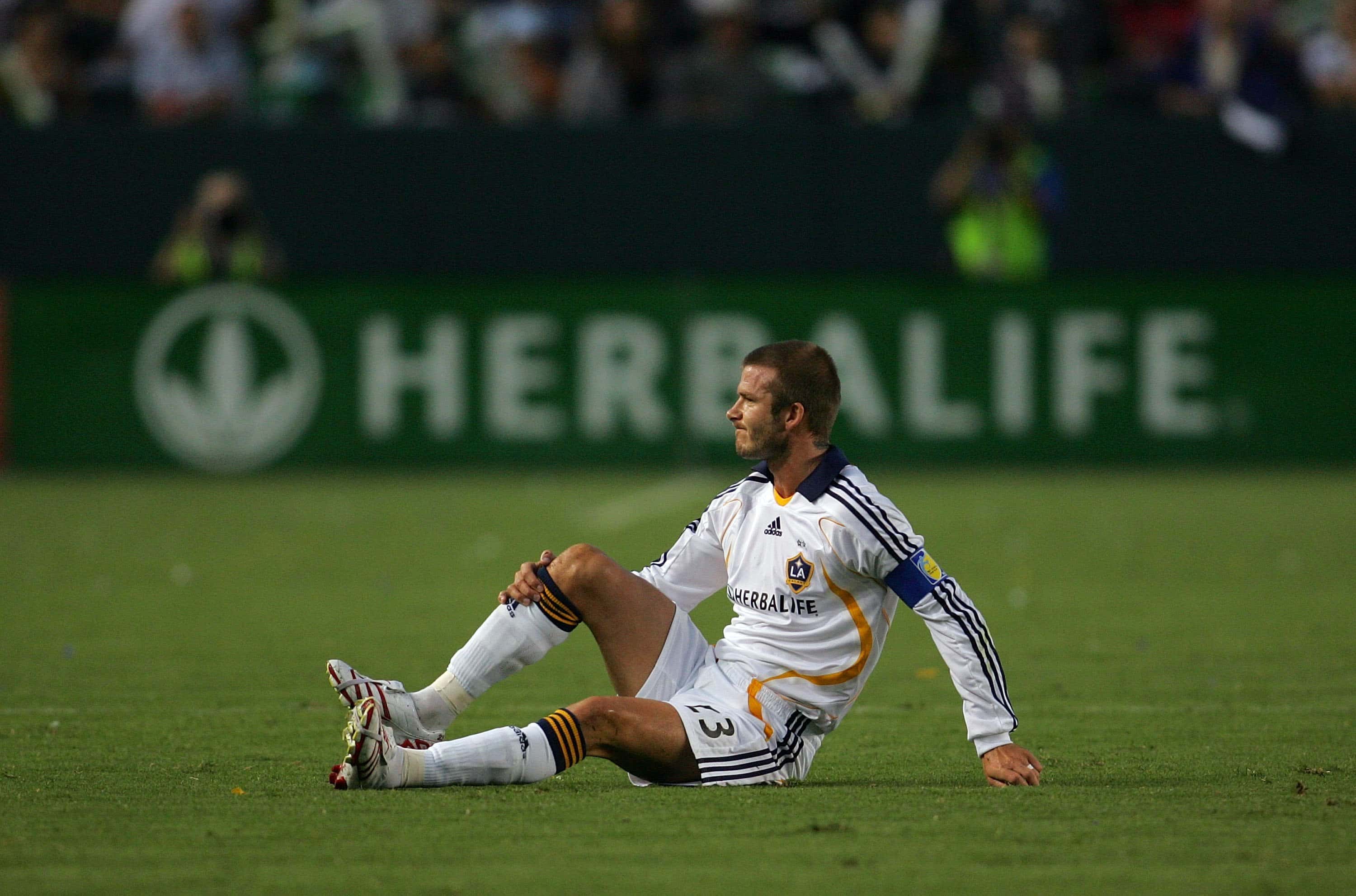 Captain David Beckham #23 of the Los Angeles Galaxy holds his right shin after falling to the ground 