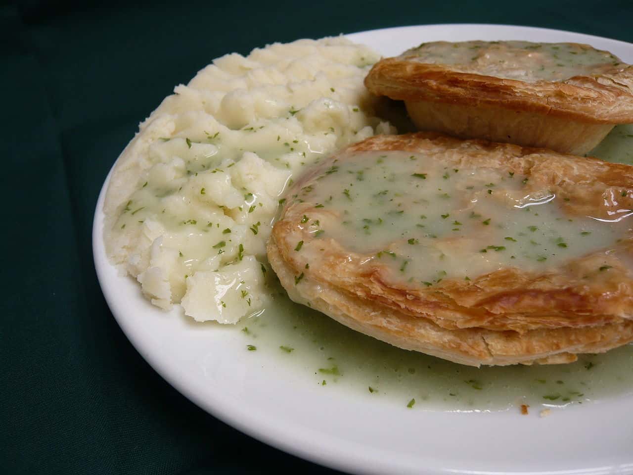 A plate of traditional London pie, mashed potato with liquor gravy